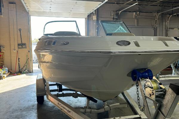 2023 Crownline 215 XS boat on trailer in garage setting.