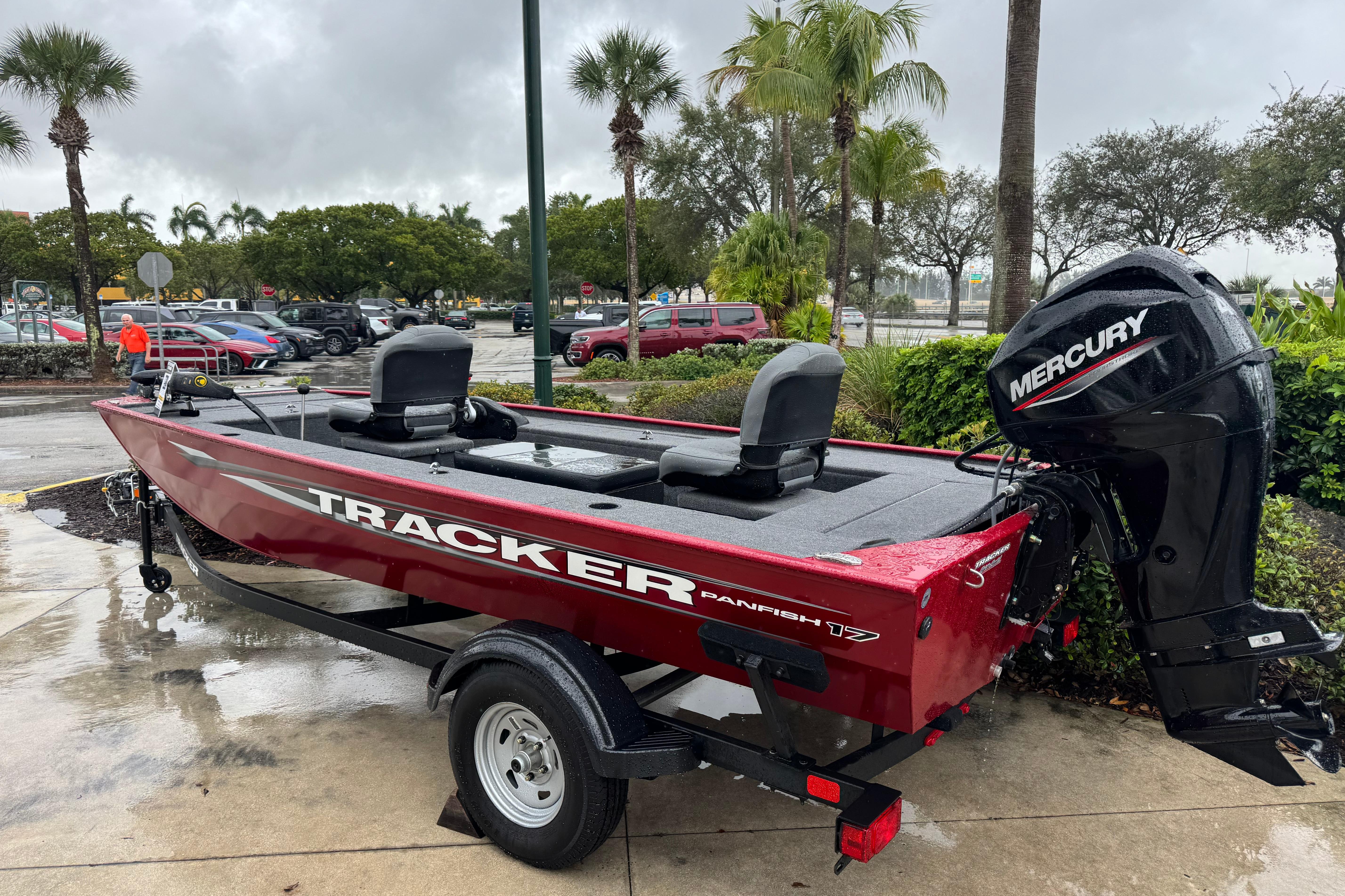 2025 Tracker Panfish 17 boat with Mercury engine, parked outdoors on a rainy day.