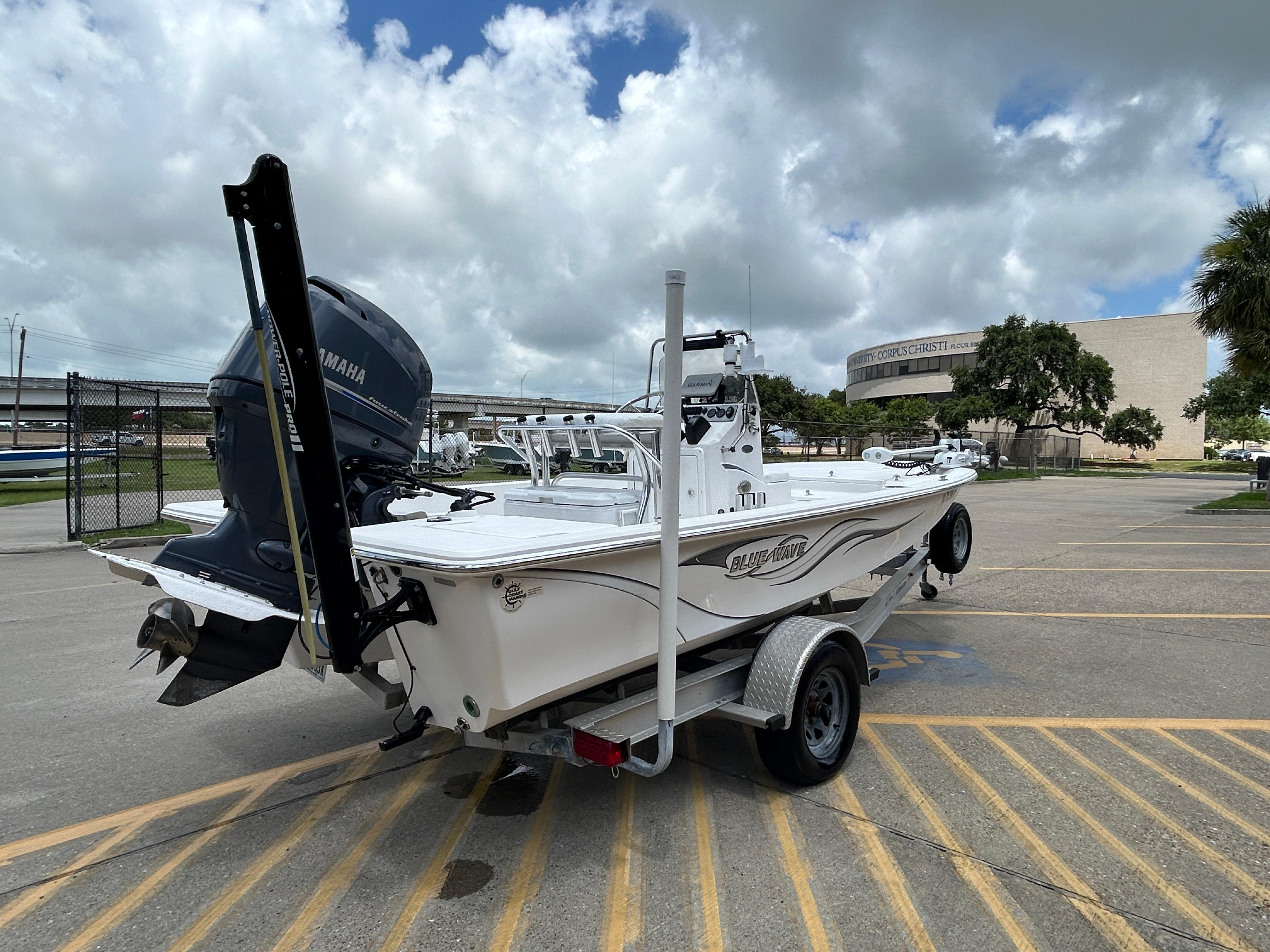 2012 Blue Wave 1900 STL boat on trailer, parked outdoors under cloudy sky.