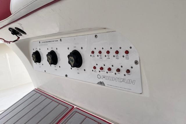 Control panel of a 2001 Fountain 38 Center Console boat with switches and dials.