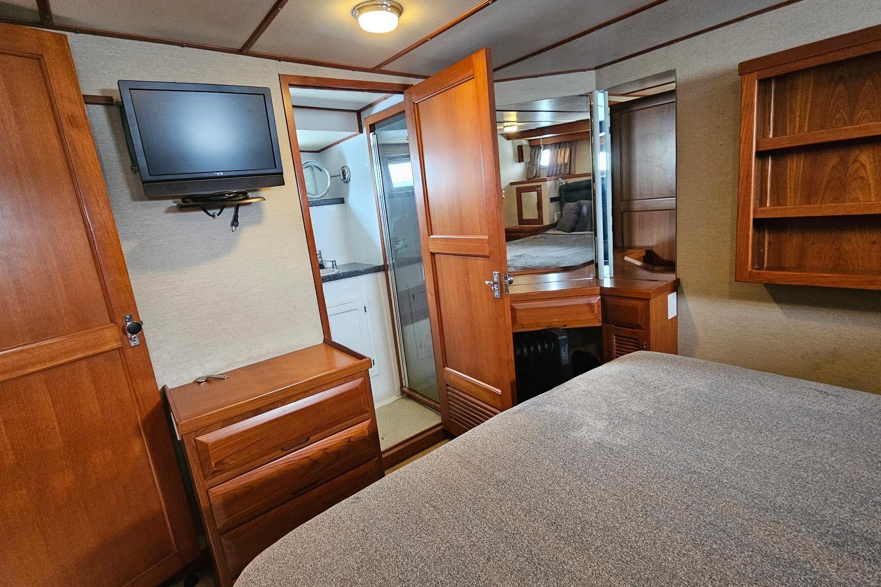 1987 DeFever 53 POC yacht interior with wood cabinetry, TV, and cozy bedroom.
