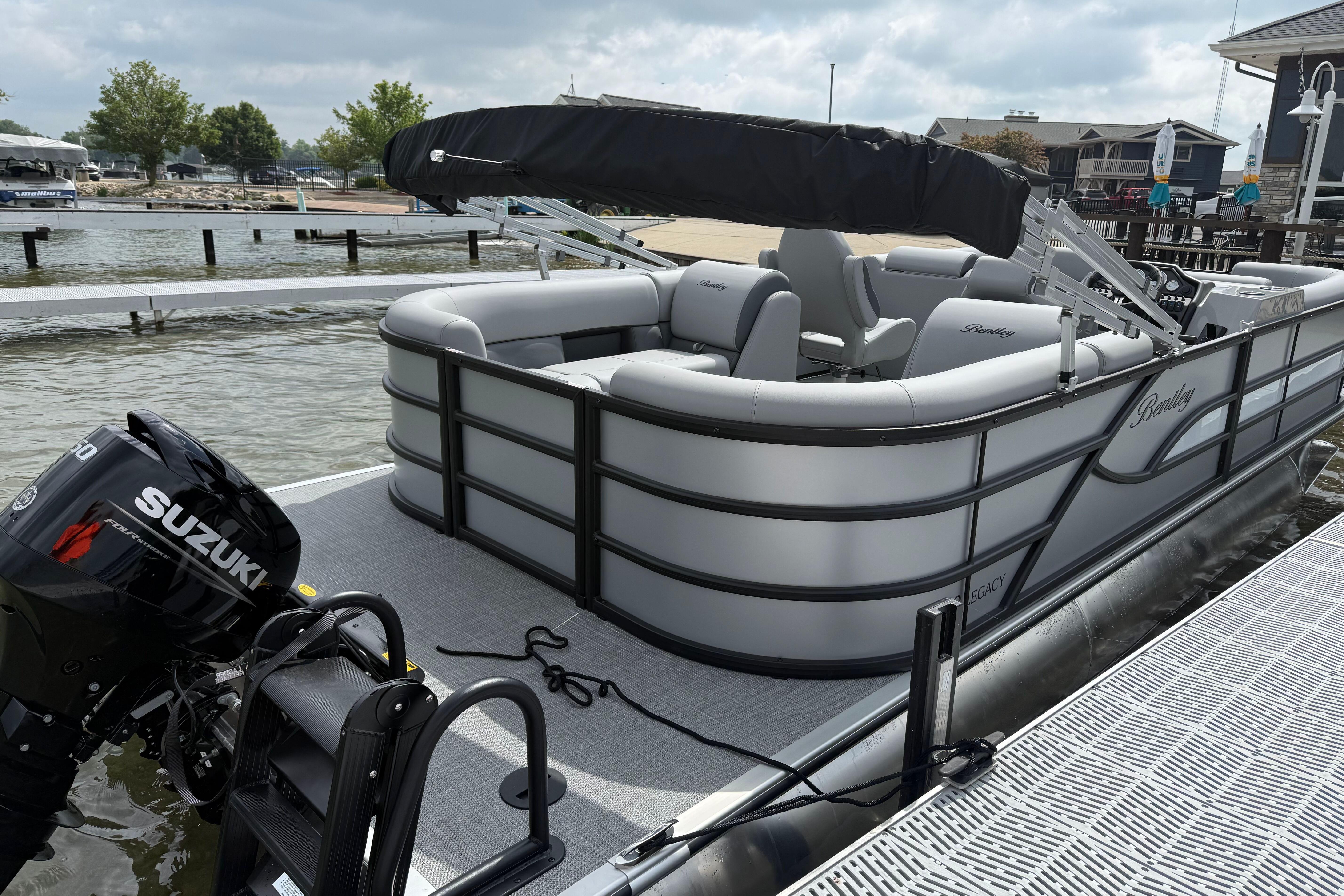 2026 Bentley Pontoons Legacy 220 Navigator docked with Suzuki outboard motor.