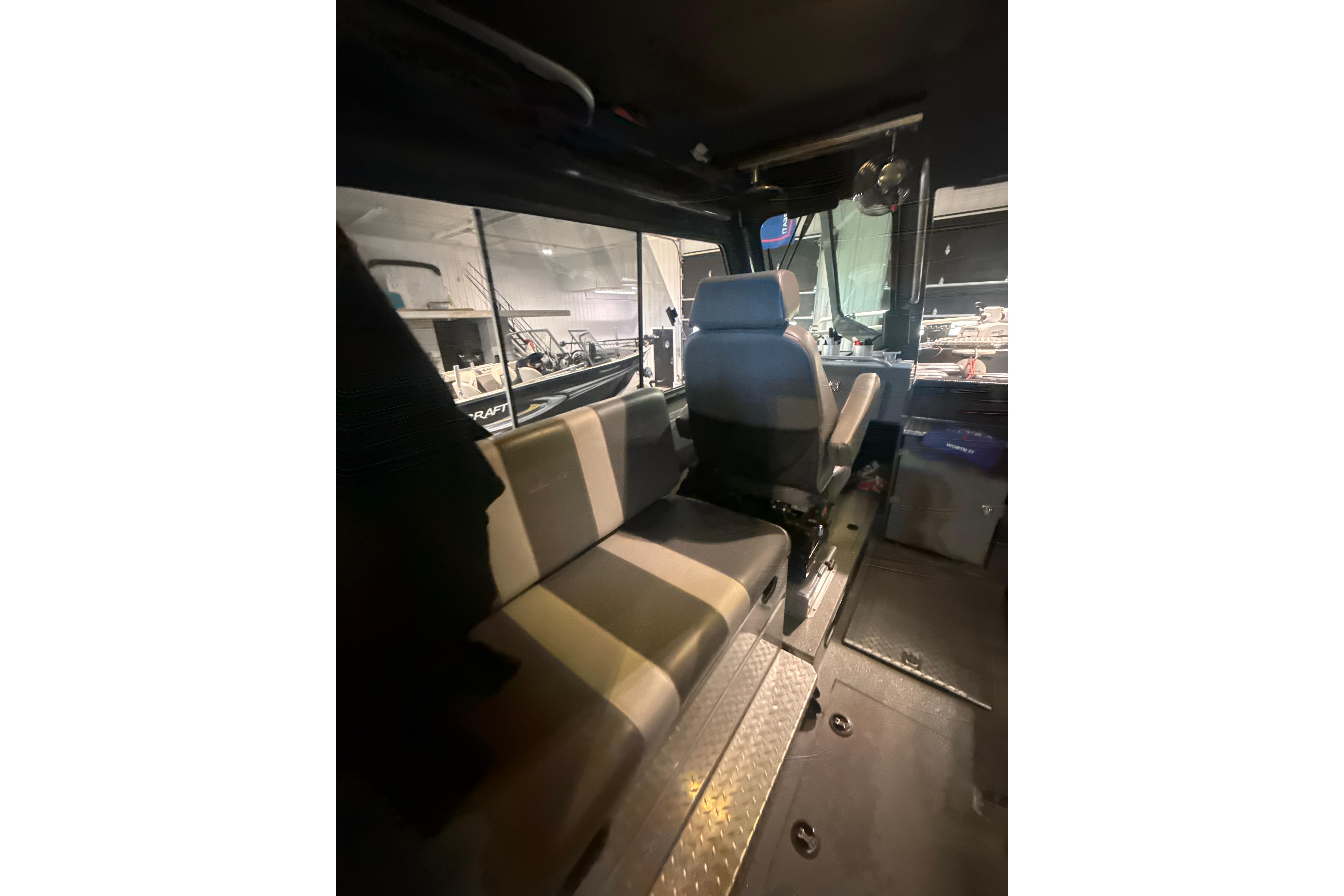 Interior of 2022 Hewescraft 270 Alaskan Hardtop, featuring seating and helm area.