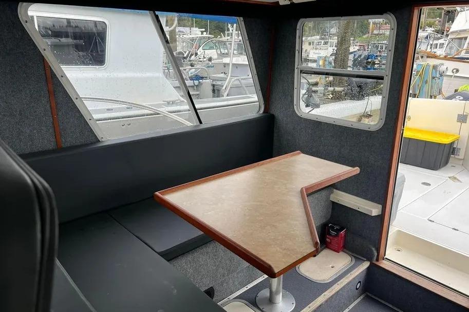 Interior of 2001 SeaSport Pacific 3200 boat with seating and table, docked at marina.