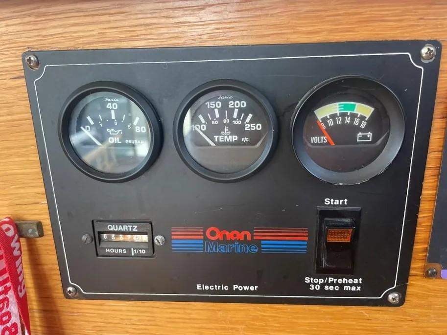 Control panel of a 1985 Princess Sedan Flybridge with gauges and Onan Marine branding.