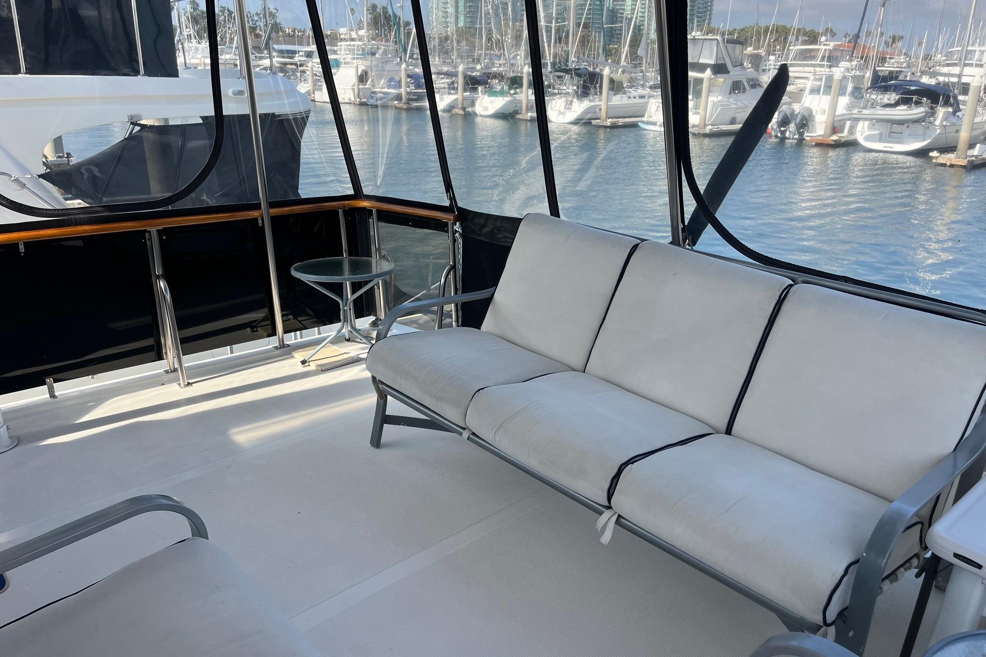 1989 Ocean Alexander 440 Sundeck CPMY interior with white seating, marina view.