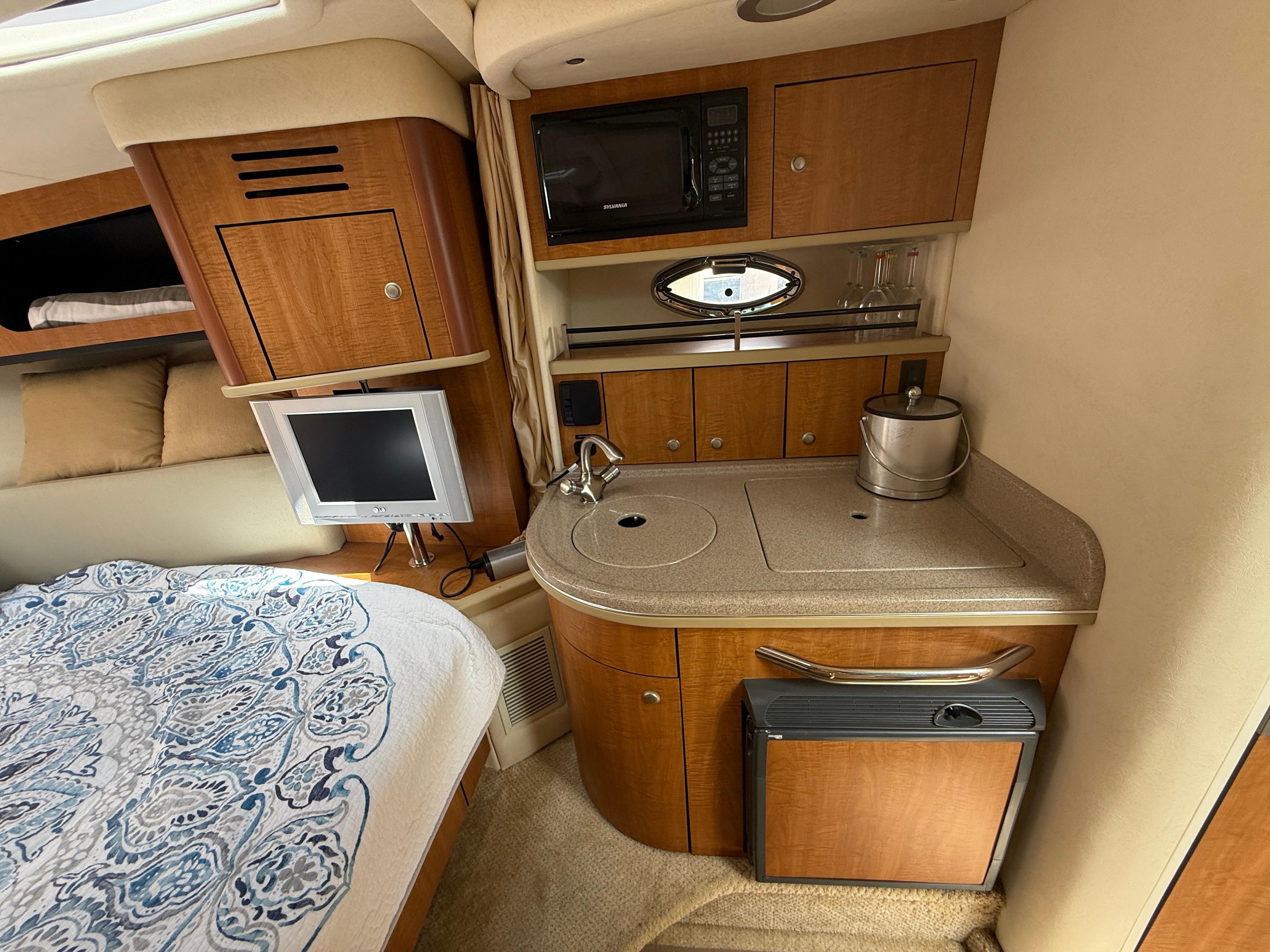 2006 Sea Ray 290 Sundancer cabin with kitchenette, TV, and bed.