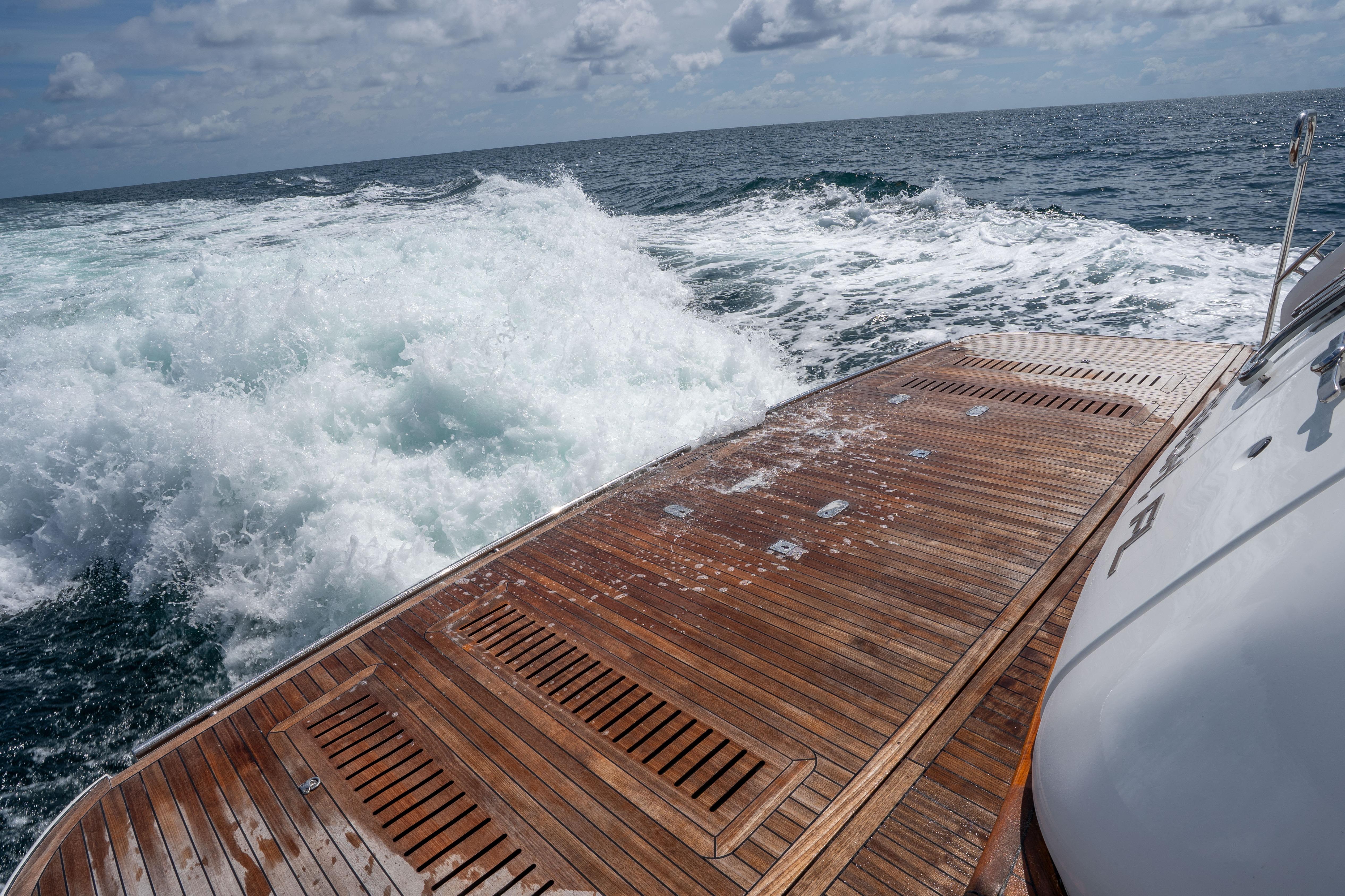 Luxury yacht Princess Y85 cruising through ocean waves, showcasing elegant wooden deck.