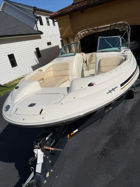 A 2001 Sea Ray 210 Sundeck boat on a trailer in a driveway.