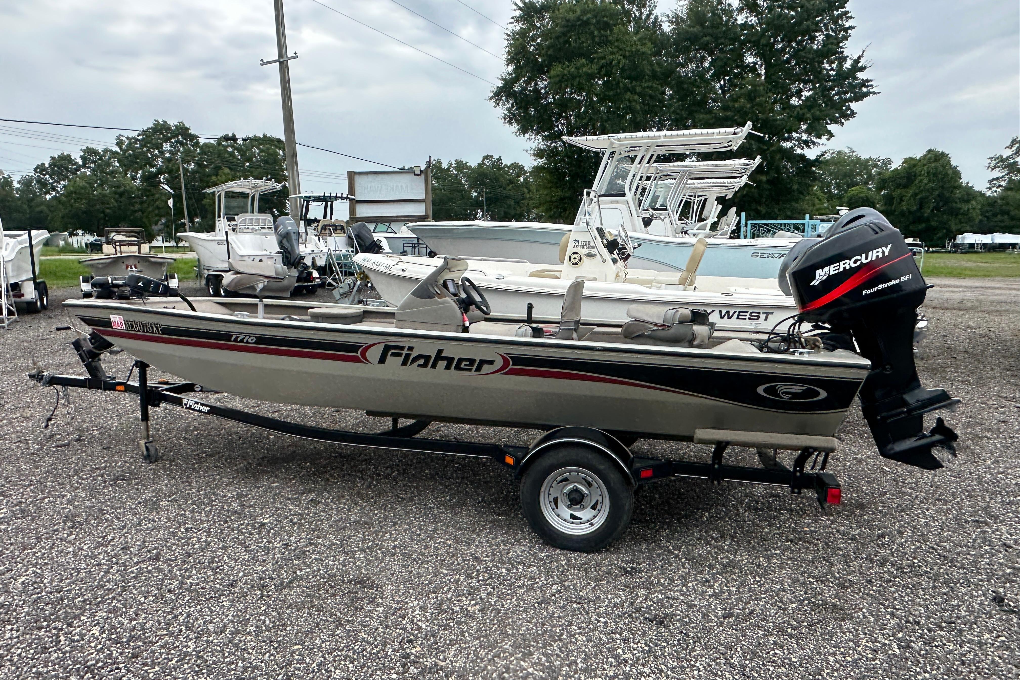 2002 Fisher 1710 boat with Mercury engine on trailer in outdoor setting.