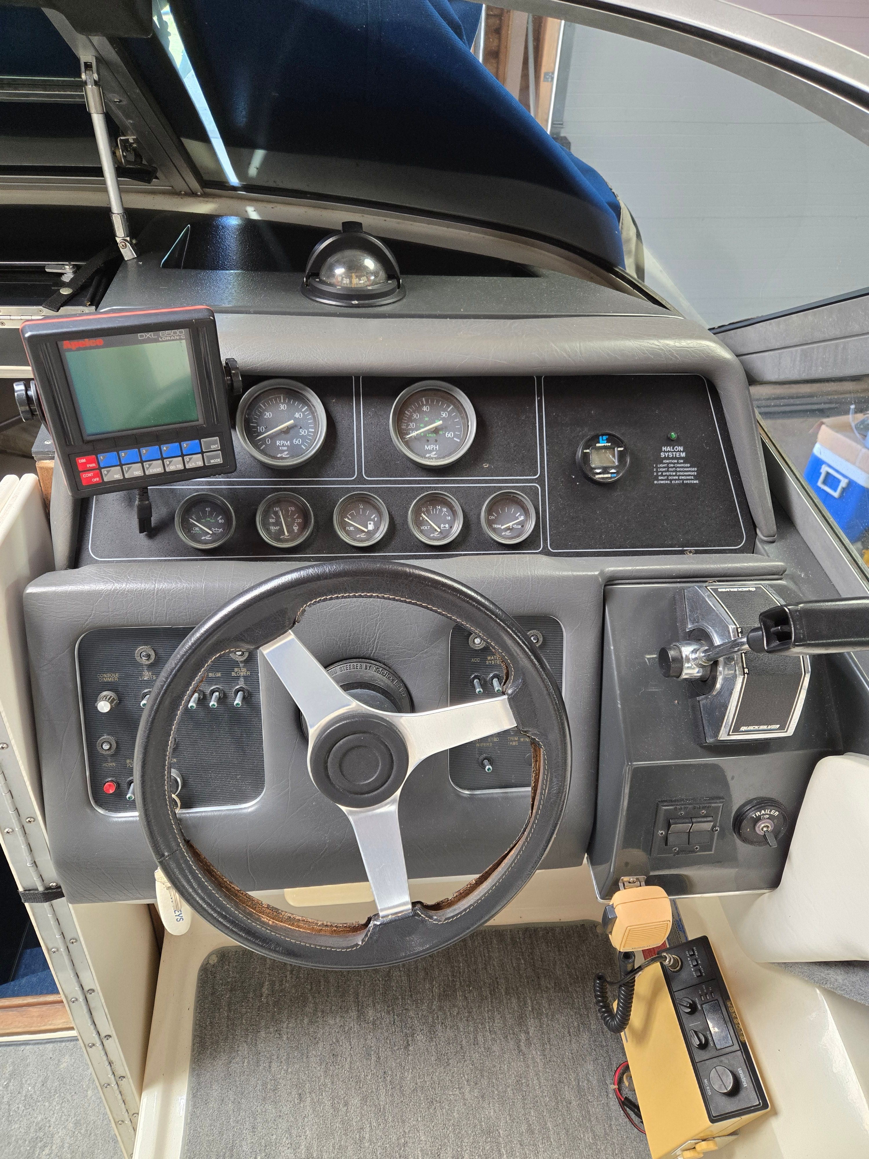 The image shows the cockpit of a 1991 Sea Ray 250 Weekender with a steering wheel and instruments.
