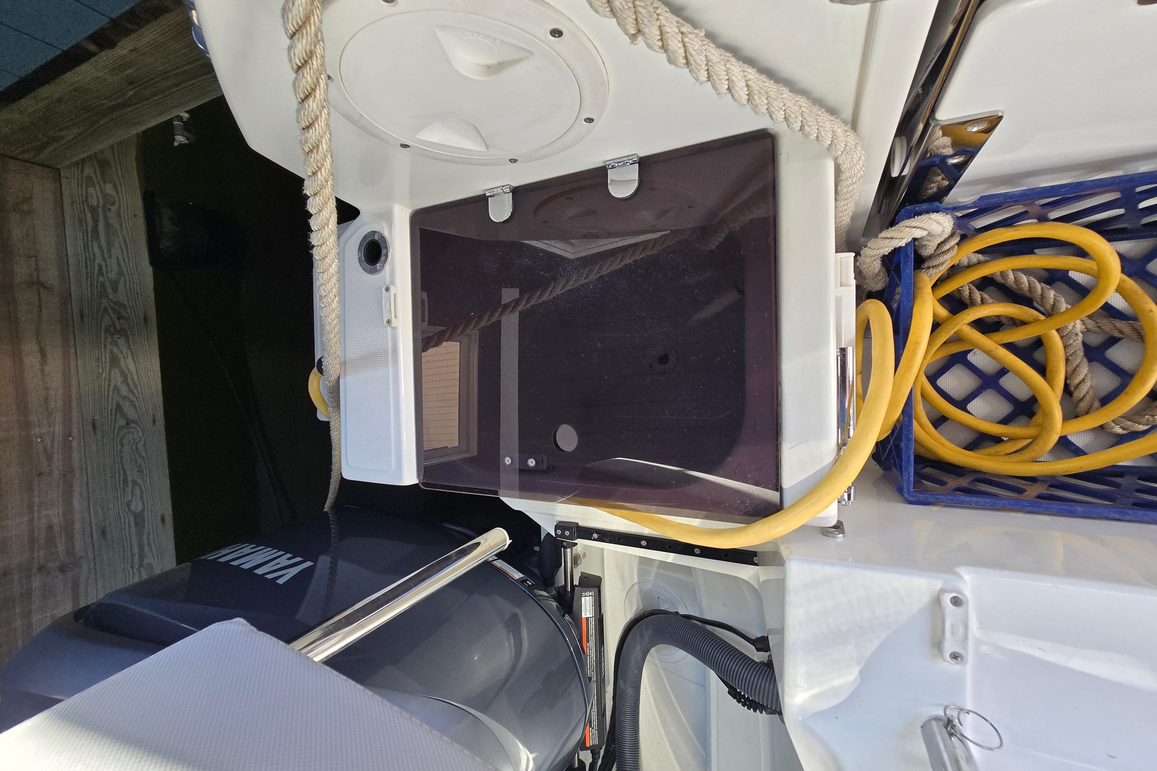 The image shows the stern of a Jeanneau NC Sport 895 with an outboard motor and ropes.