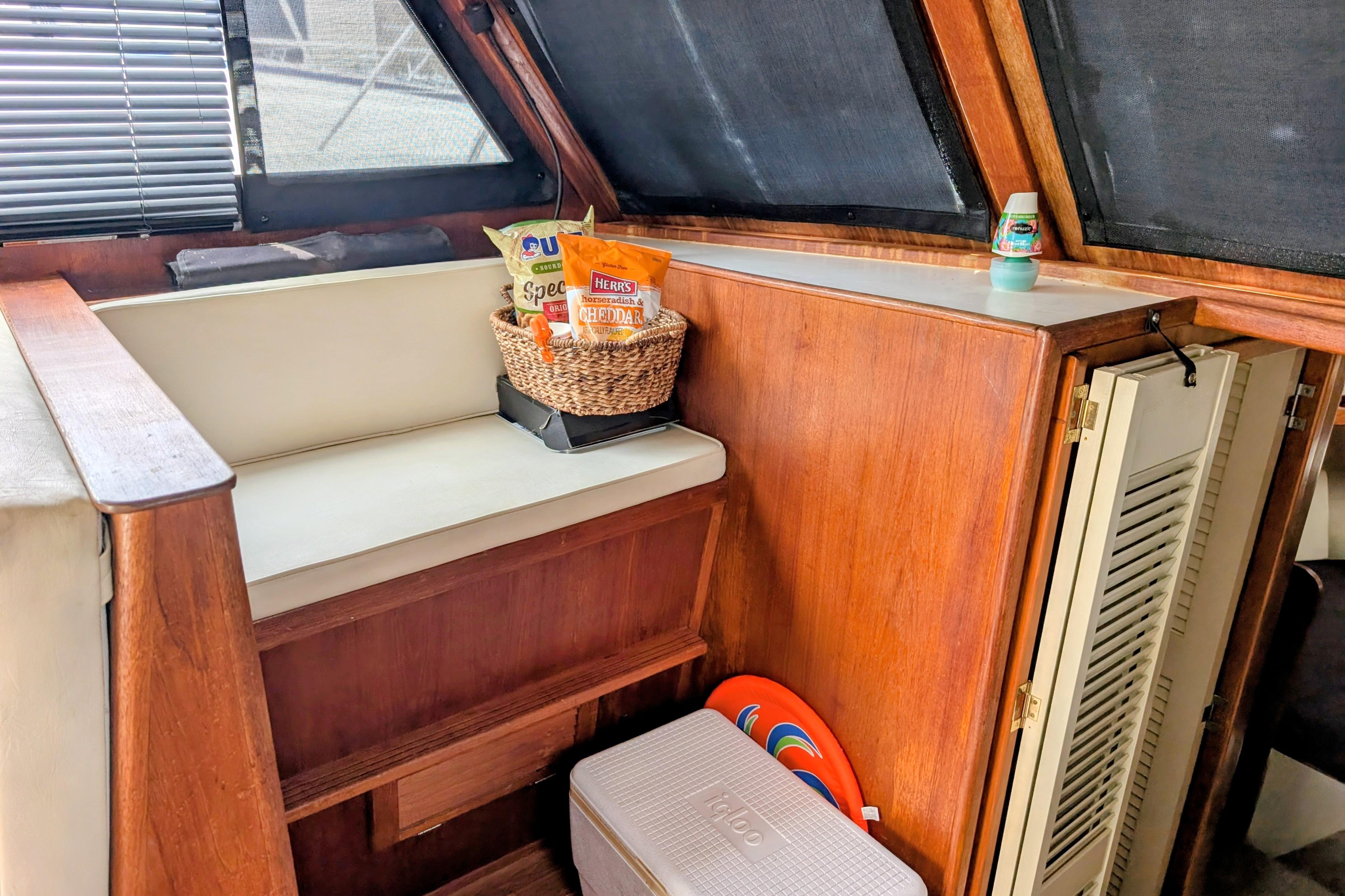 Cozy interior of 1998 Markley 46 boat with snacks and cooler.