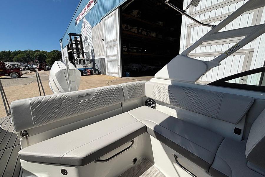 2027 Sea Ray SDX 230 Outboard boat interior with white seating and marina backdrop.