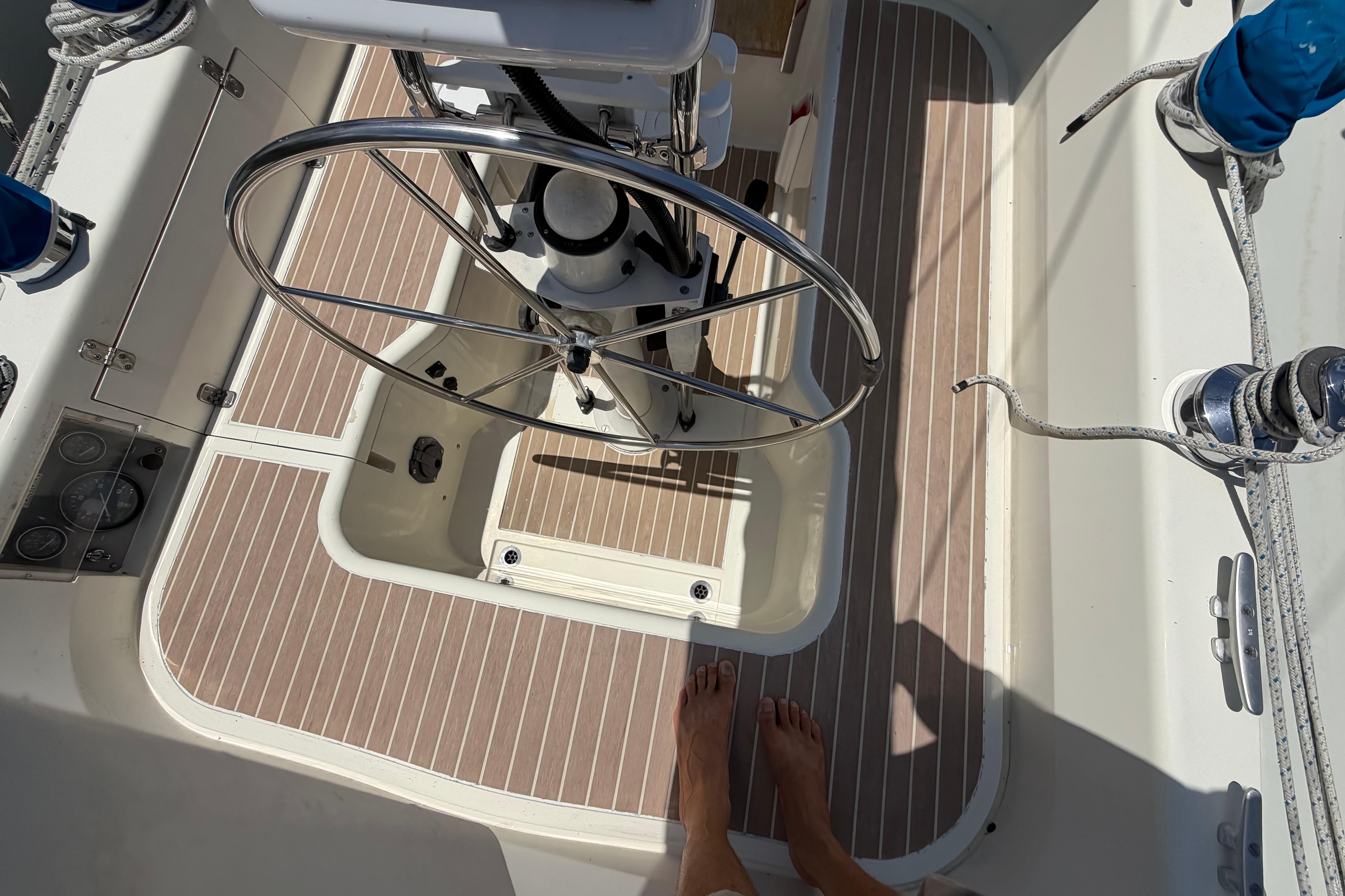 Cockpit of 1987 Moody 376 sailboat with steering wheel and teak flooring.