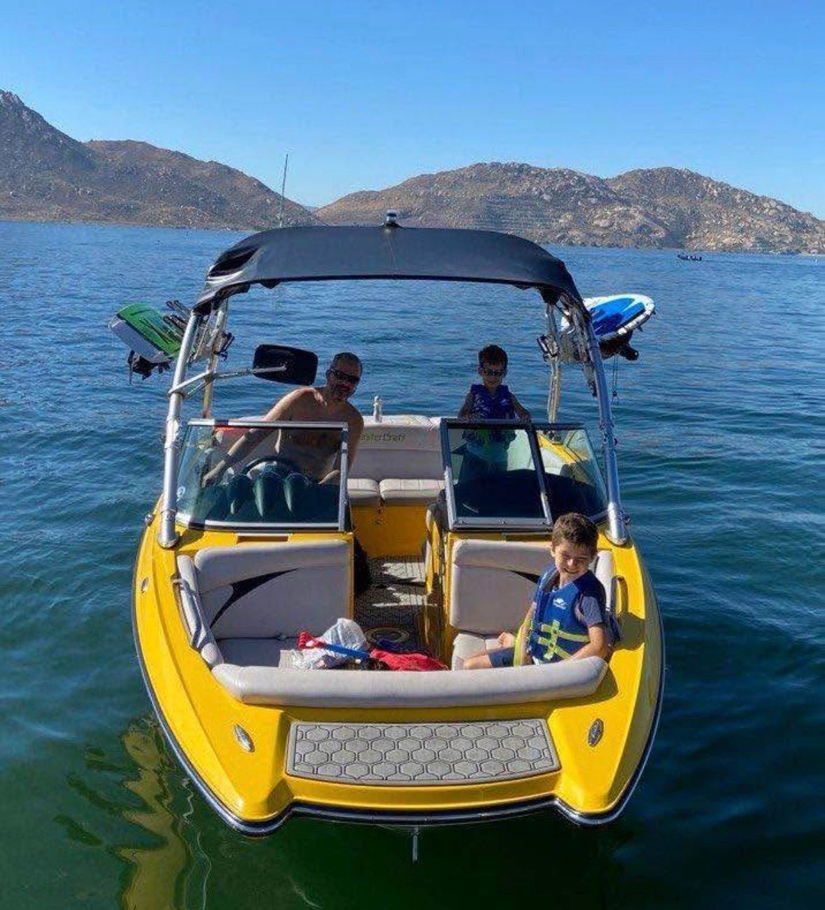 2007 MasterCraft X-2 boat with family on lake, sunny day.