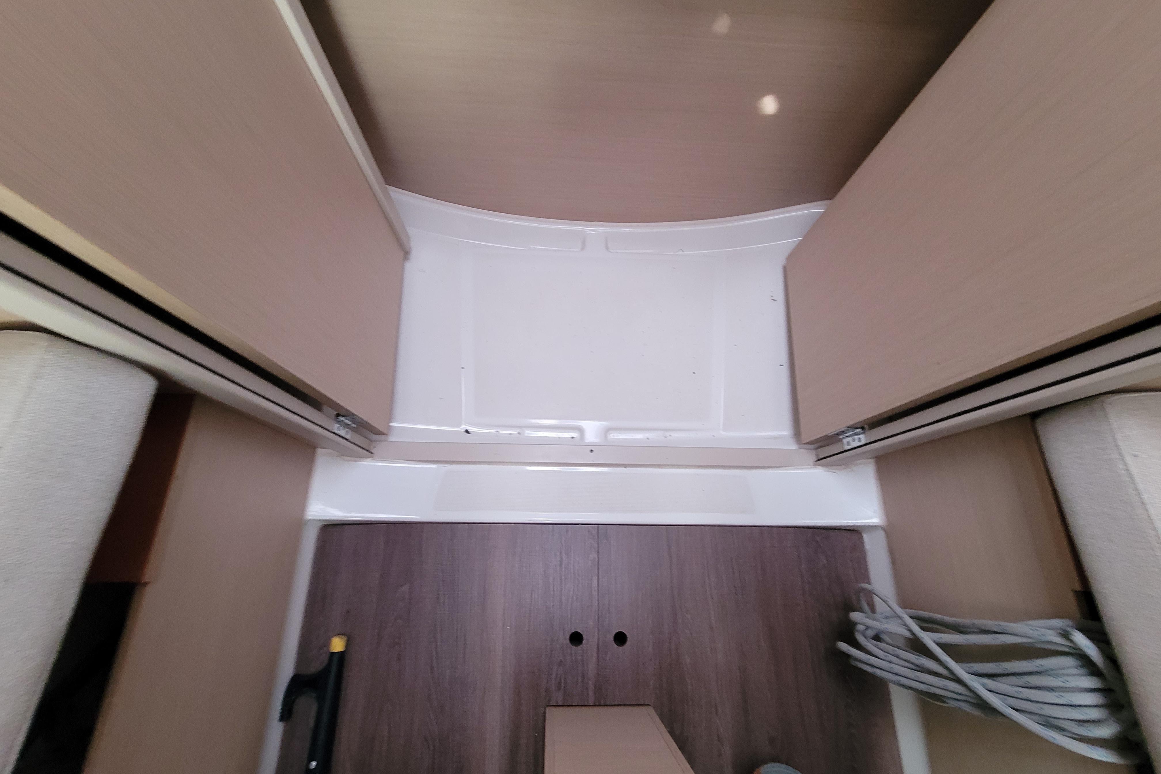 Interior view of 2020 Beneteau Oceanis 30.1 sailboat, featuring wooden flooring and storage space.