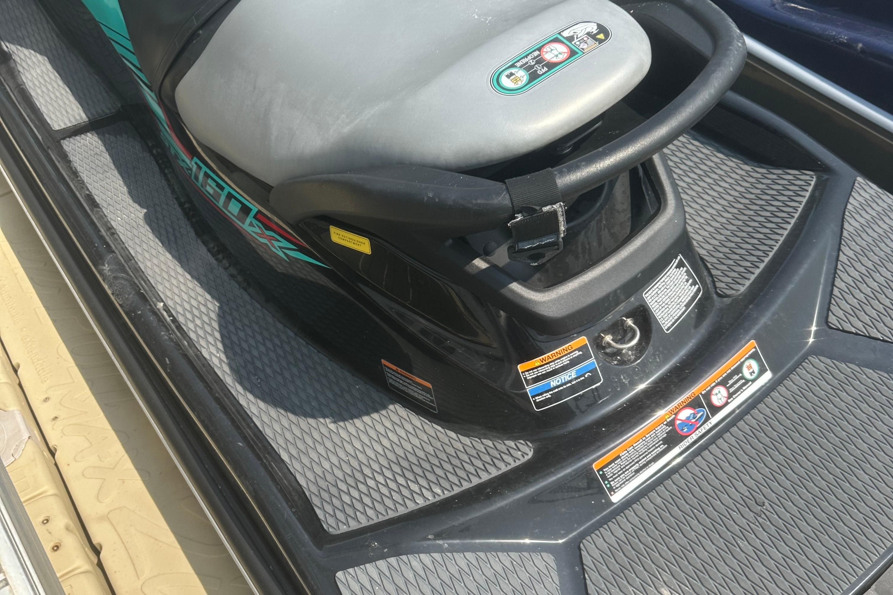 2021 Kawasaki Jetski STX 160X seat and controls, featuring safety labels and textured footrests.