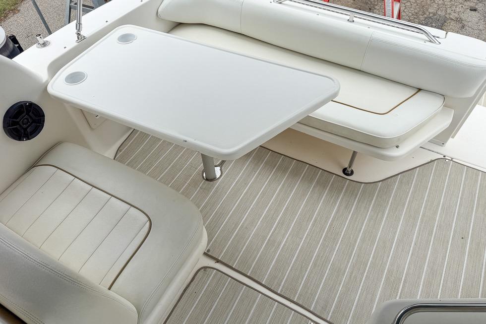 1999 Sea Ray 290 Sundancer boat interior with white seating and table.
