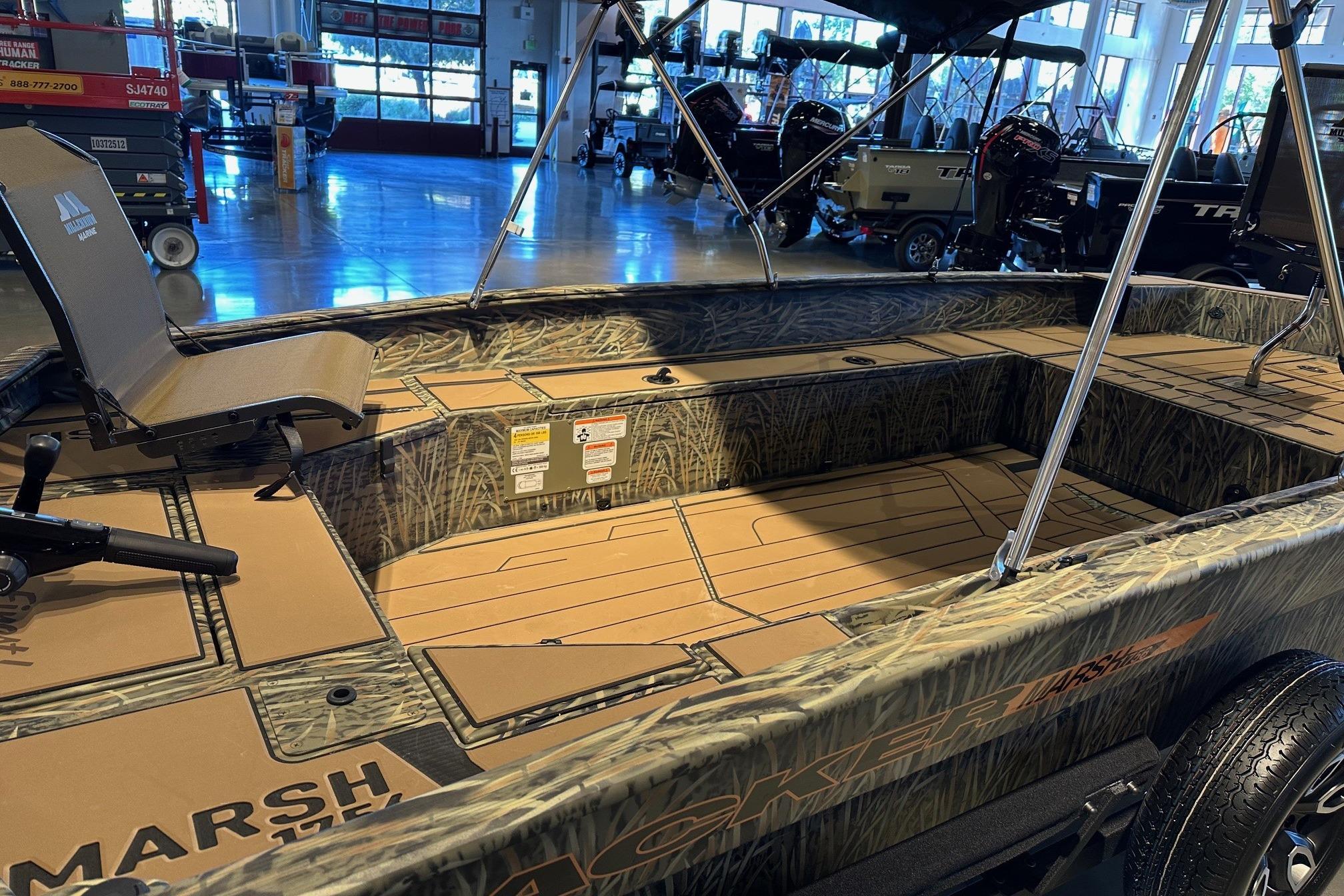 2026 Tracker Grizzly 1756 T Marsh boat interior with camouflage design in showroom.