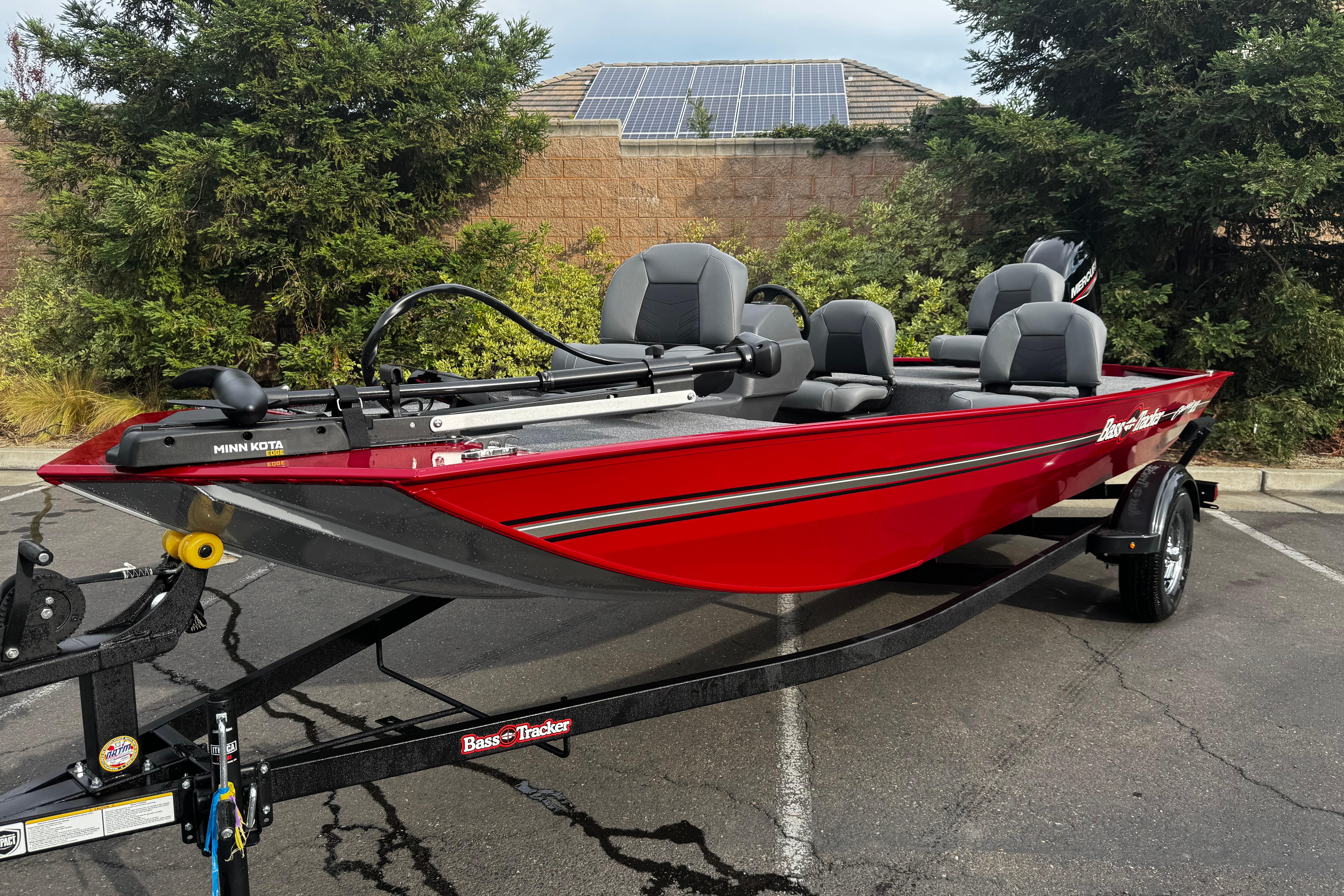 2026 Tracker Bass Tracker Classic XL boat in vibrant red, parked outdoors.