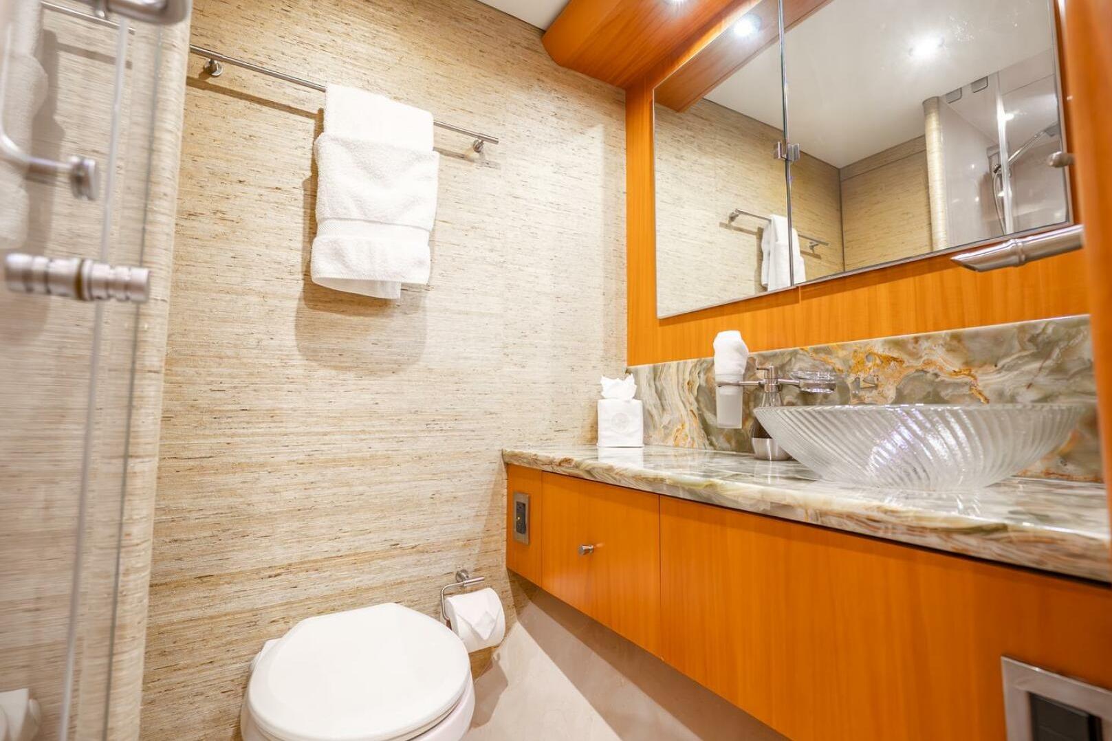 Luxurious bathroom on 2008 Lazzara Motor Yacht with elegant glass sink and marble countertop.