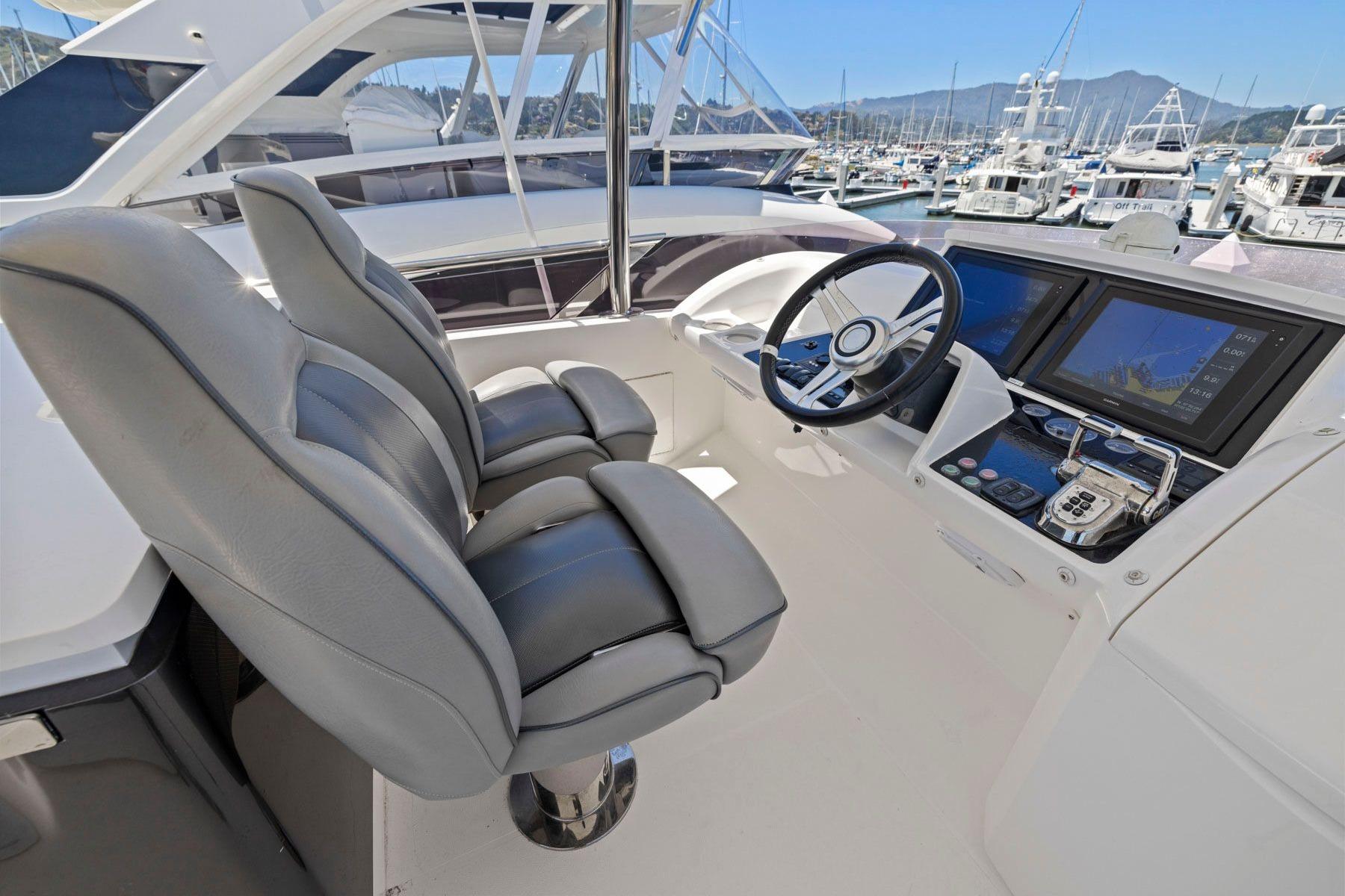 Helm of 2015 Princess 60 Flybridge Motor Yacht with dual seats and navigation screens.