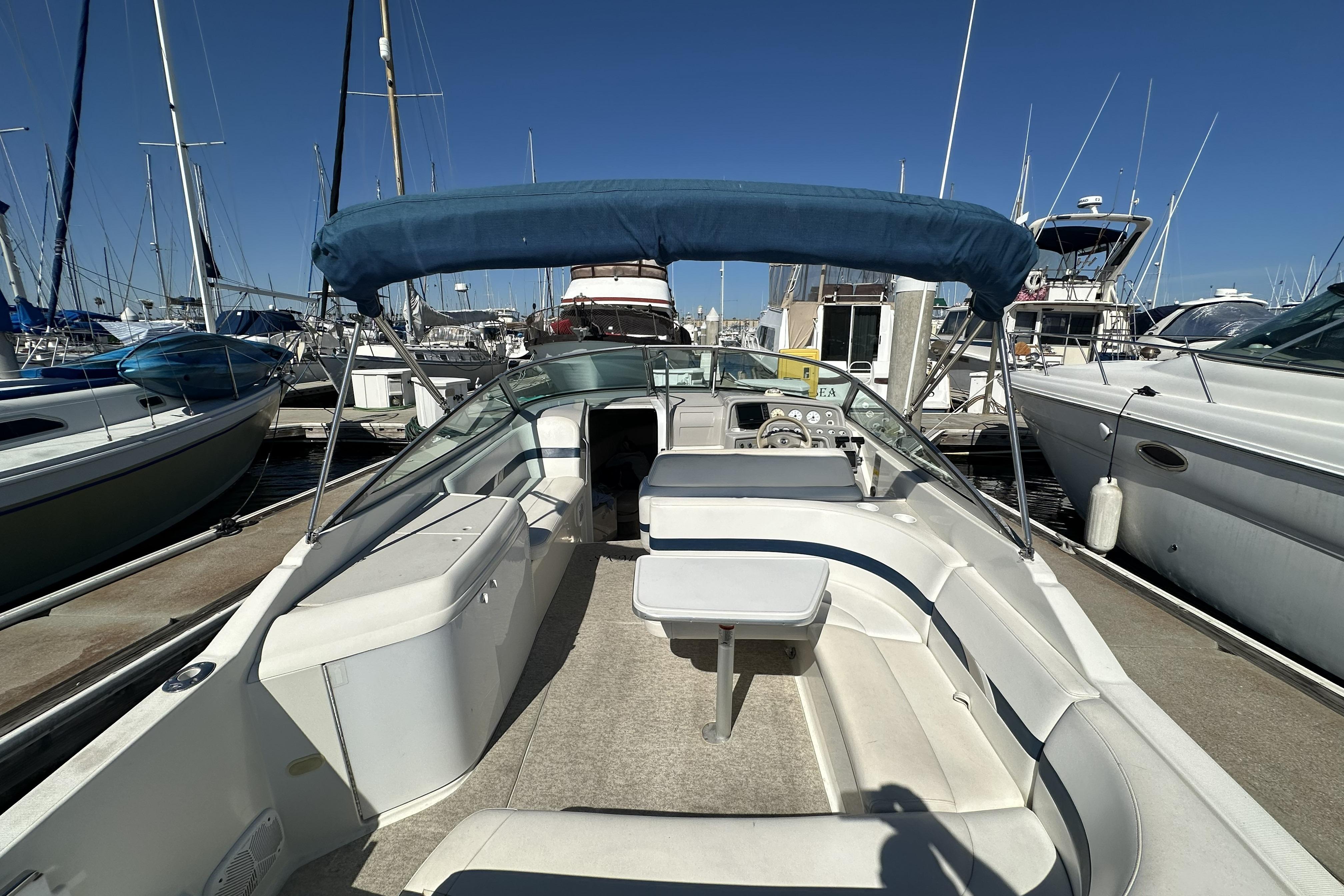 2000 Formula 280 Sun Sport boat docked at marina with blue canopy.