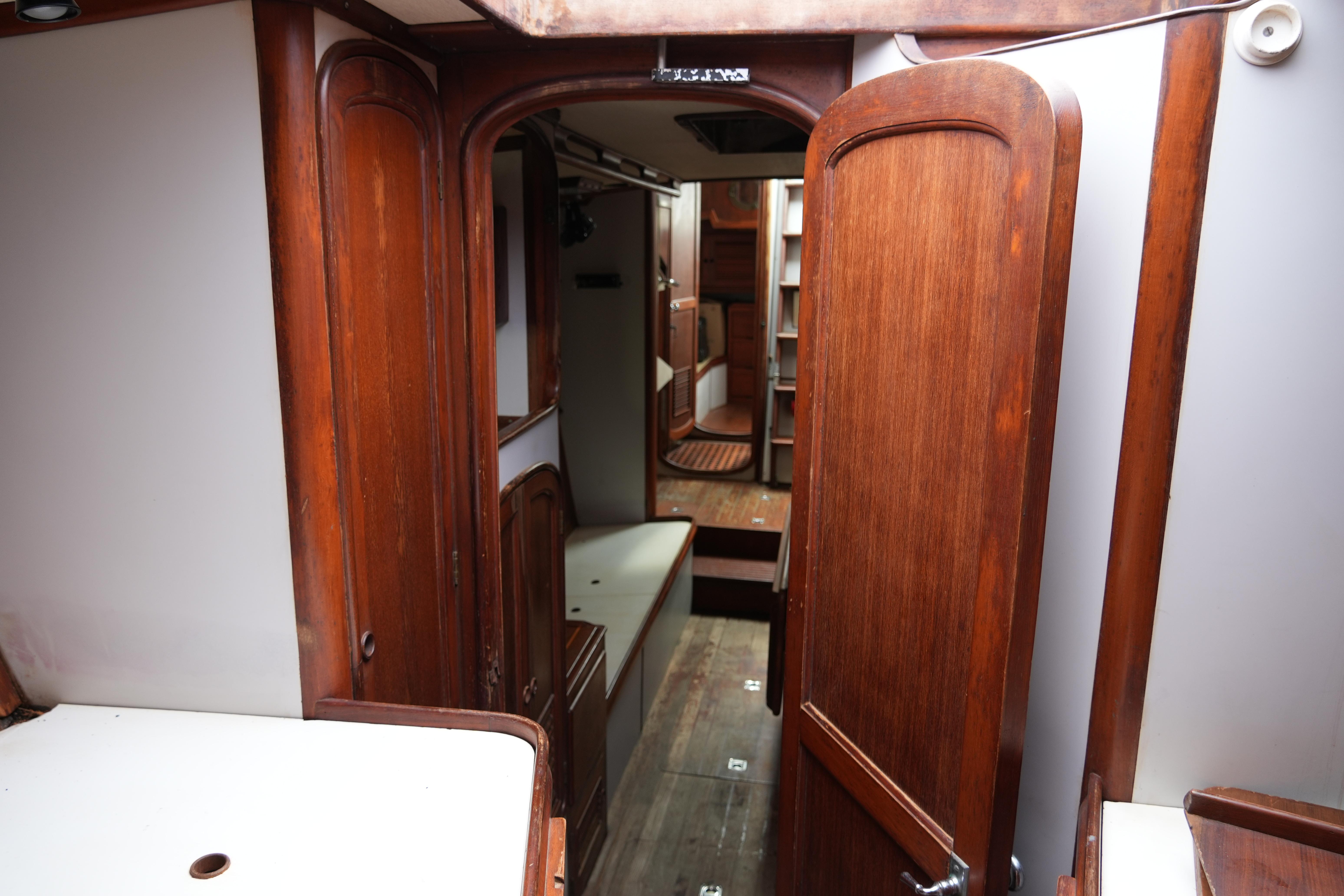 Interior of 1980 Lafitte 44 Cutter sailboat with wooden cabinetry and cozy layout.