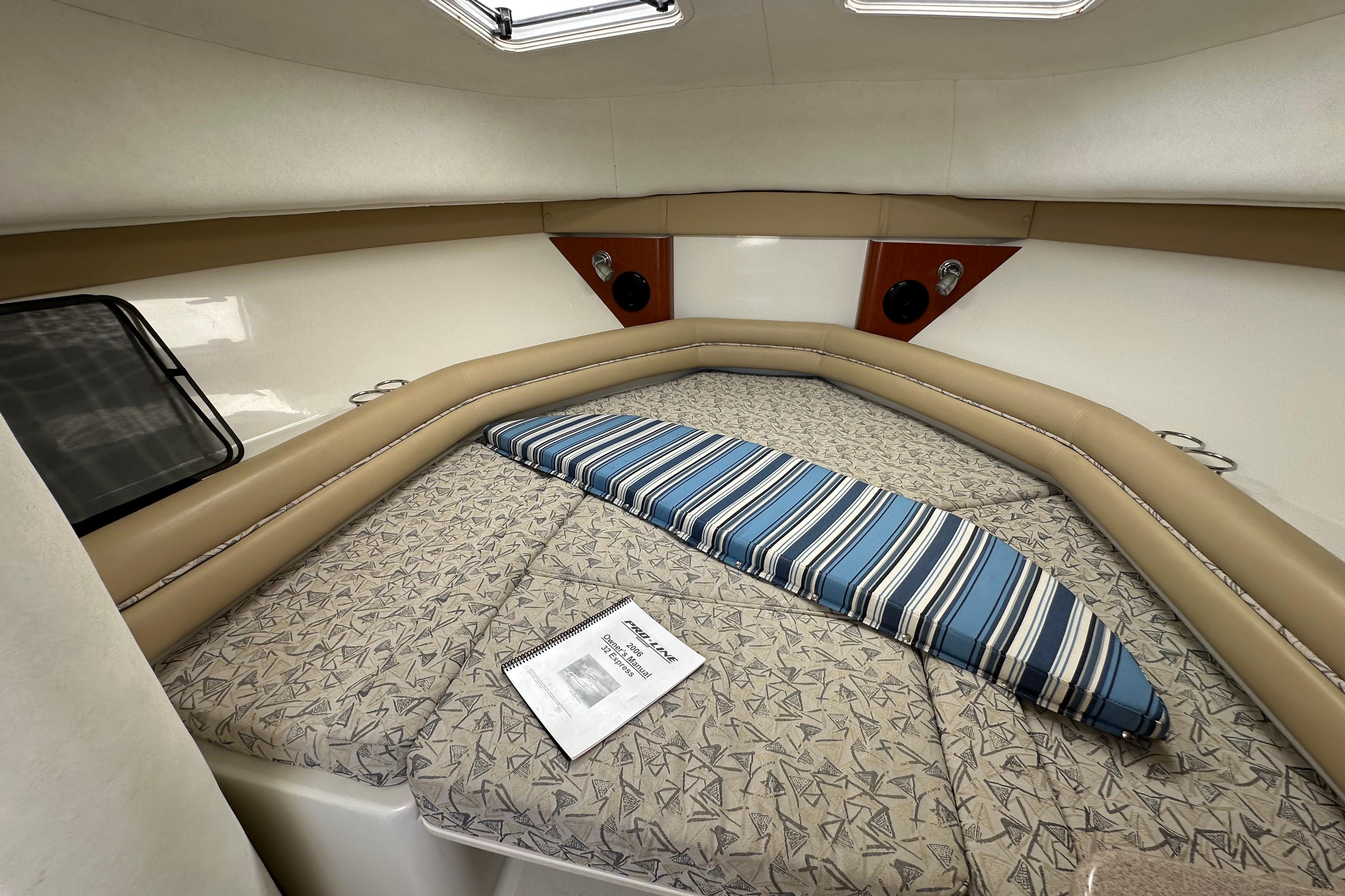 Interior cabin of 2006 Pro-Line 32 Express boat with cushioned seating and manual.