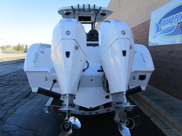 2025 Sea Pro 292 Offshore boat with dual outboard engines, docked near a building.