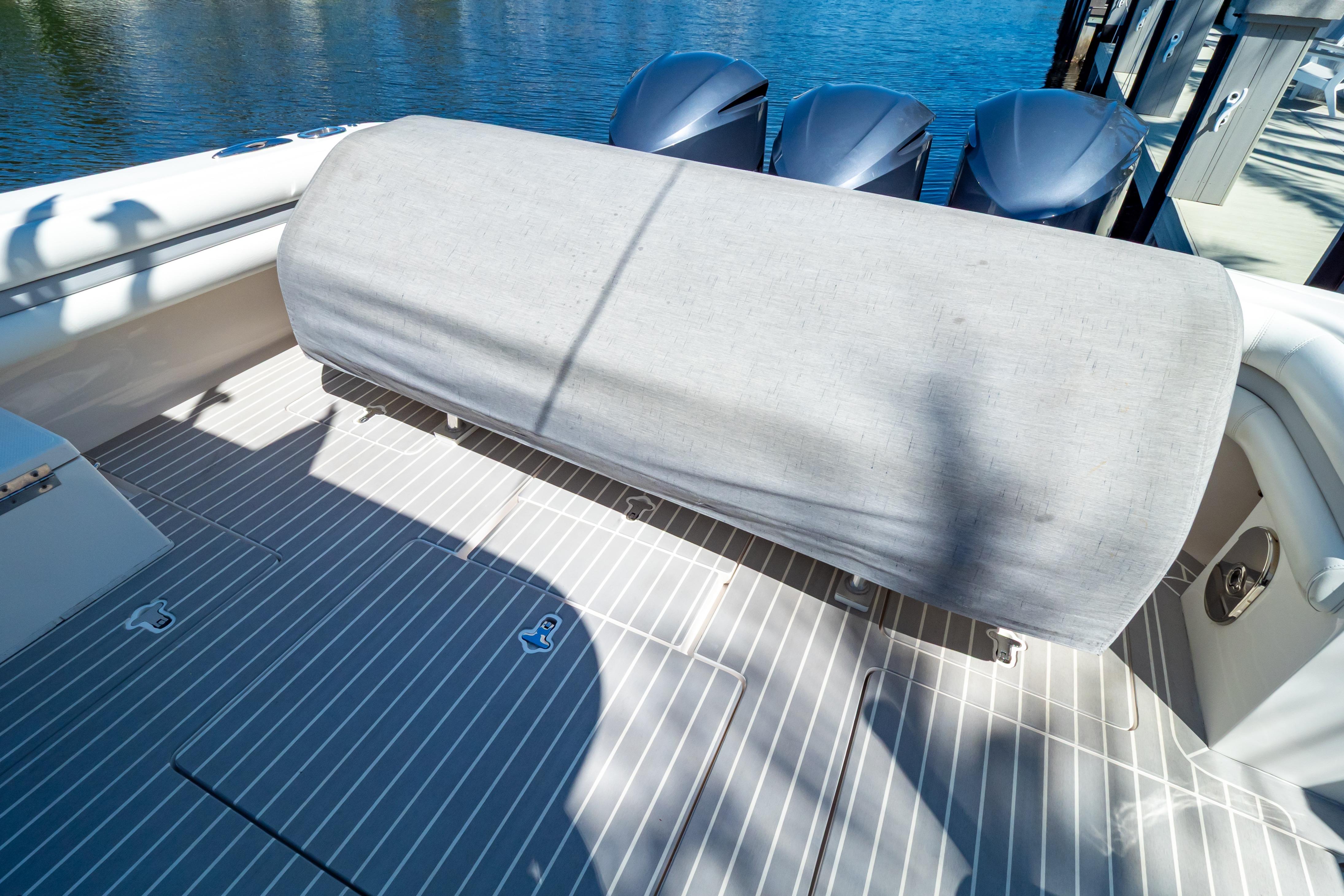 2016 Intrepid 400 Cuddy boat deck with covered seating and triple outboard engines.