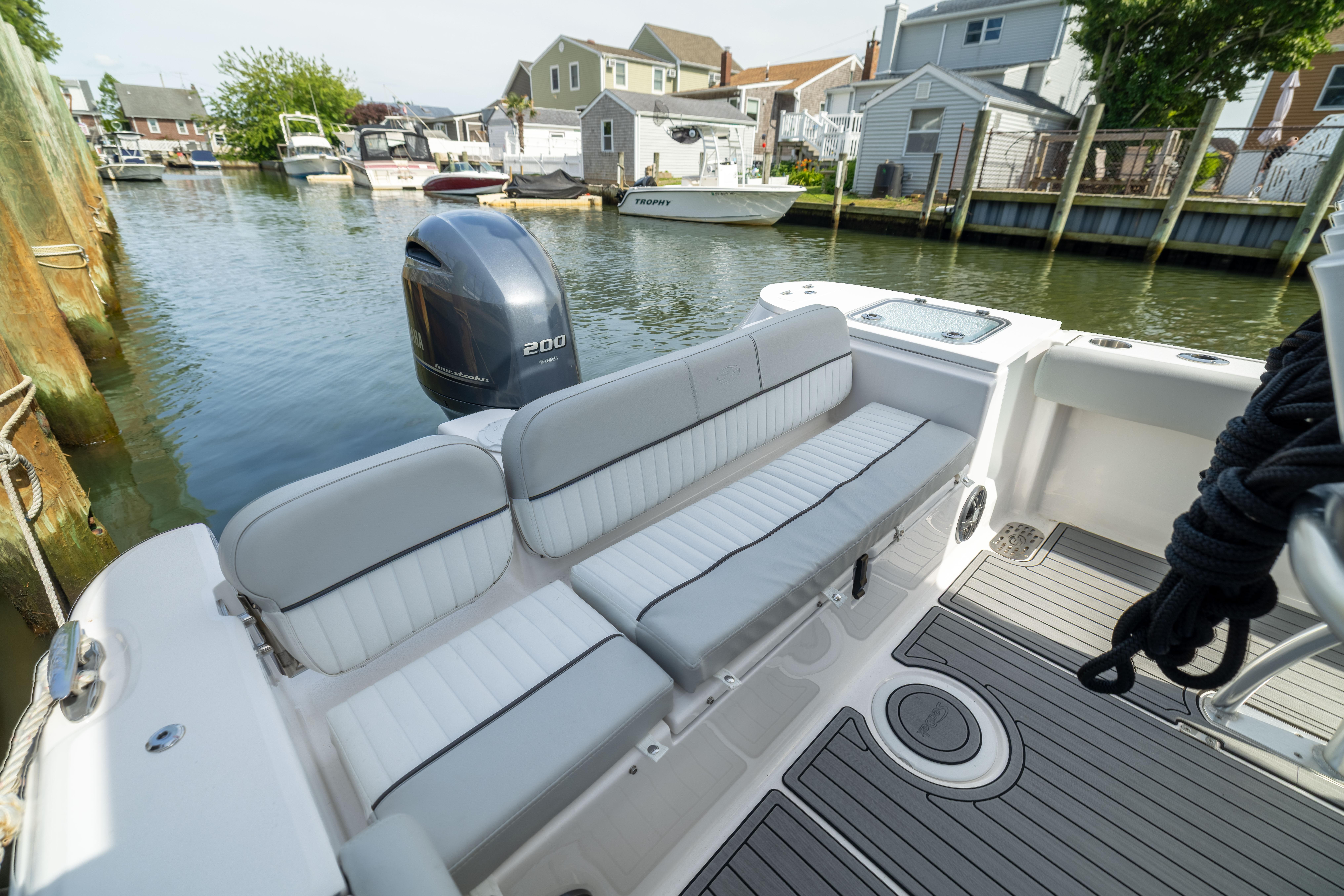 2023 Sea Fox 228 Commander boat interior with seating and outboard motor in a marina.