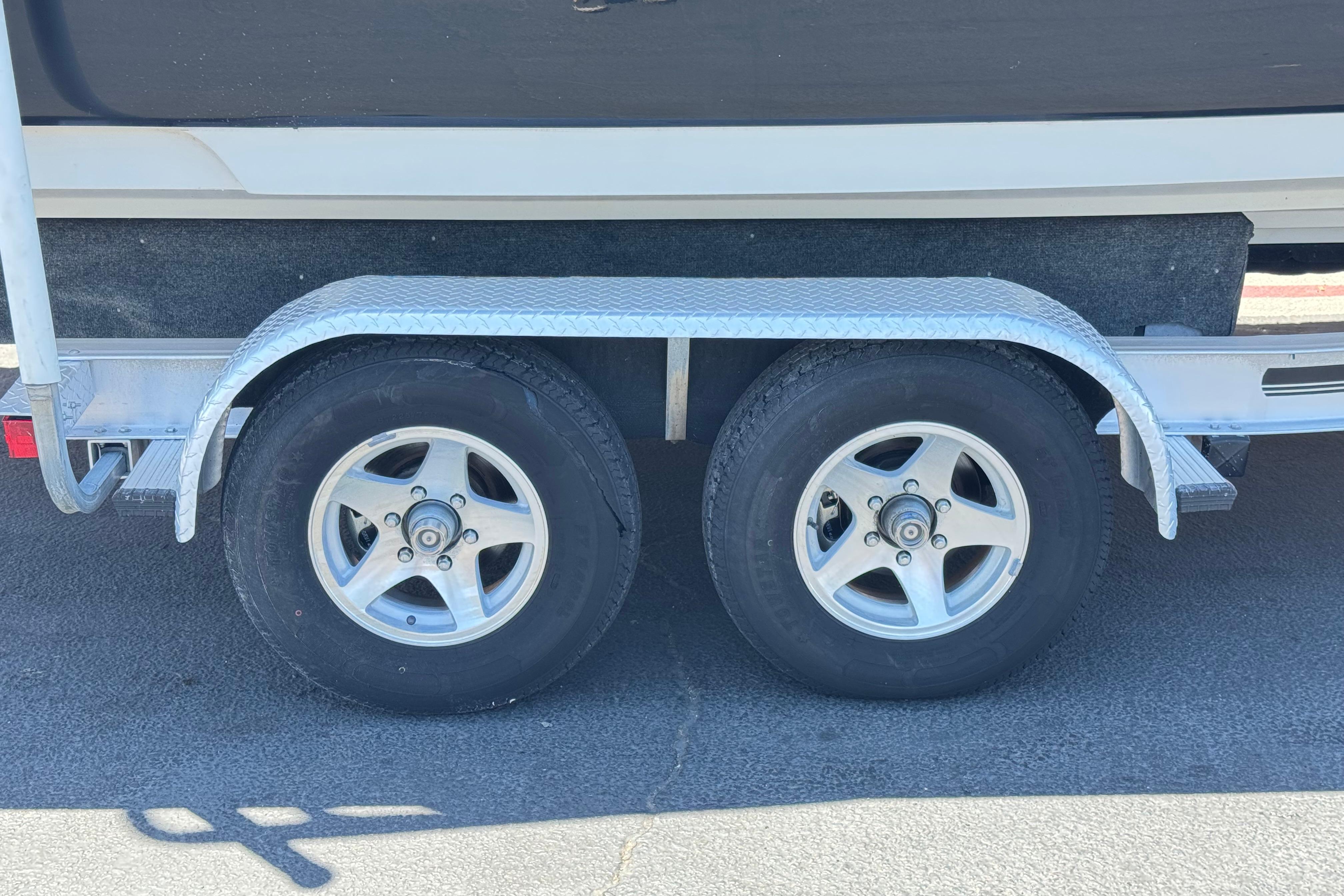 Trailer wheels of a 2007 Sea Ray 240 Sundeck boat on pavement.