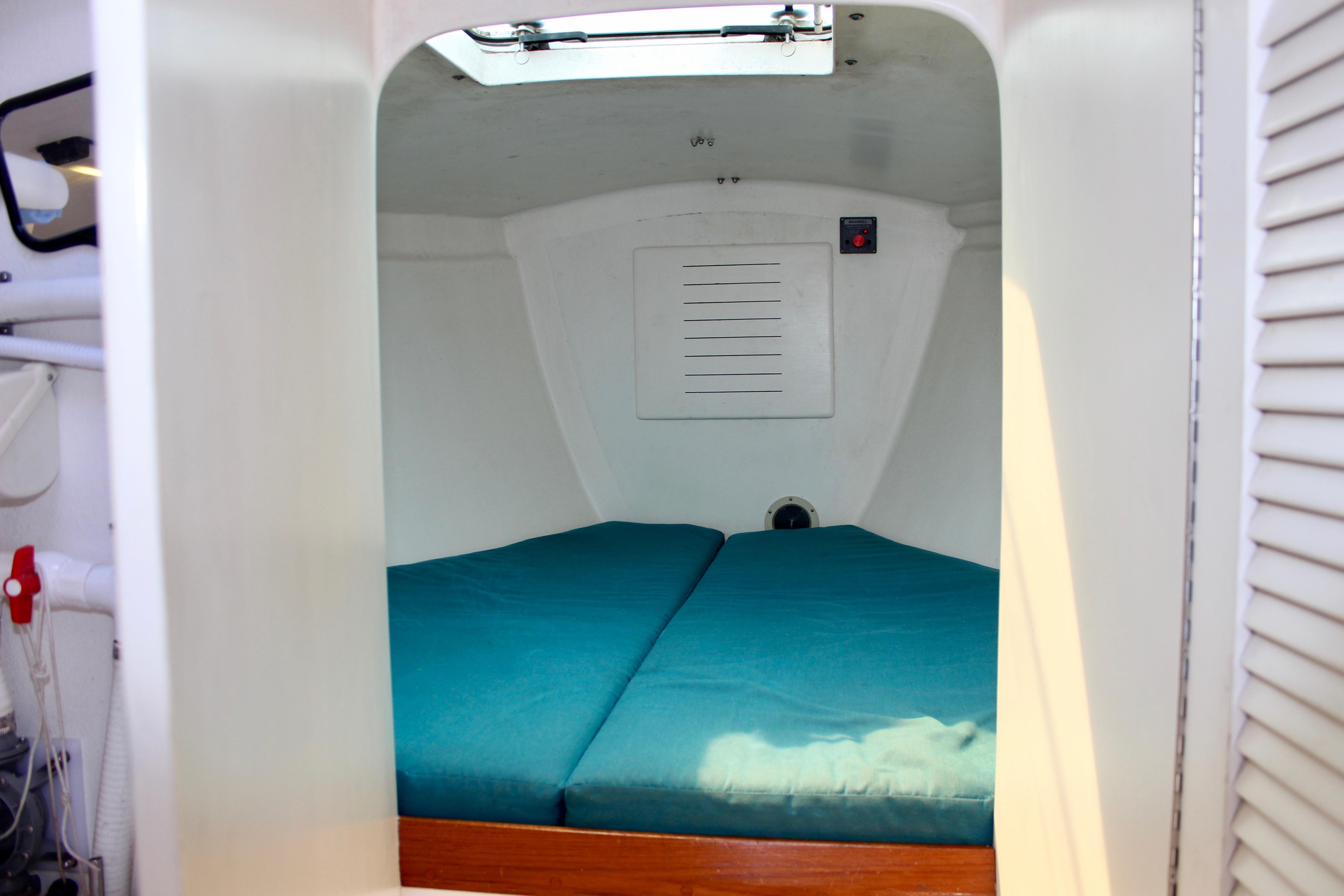 Cozy cabin interior of 1993 Freya 39 sailboat with teal bedding.