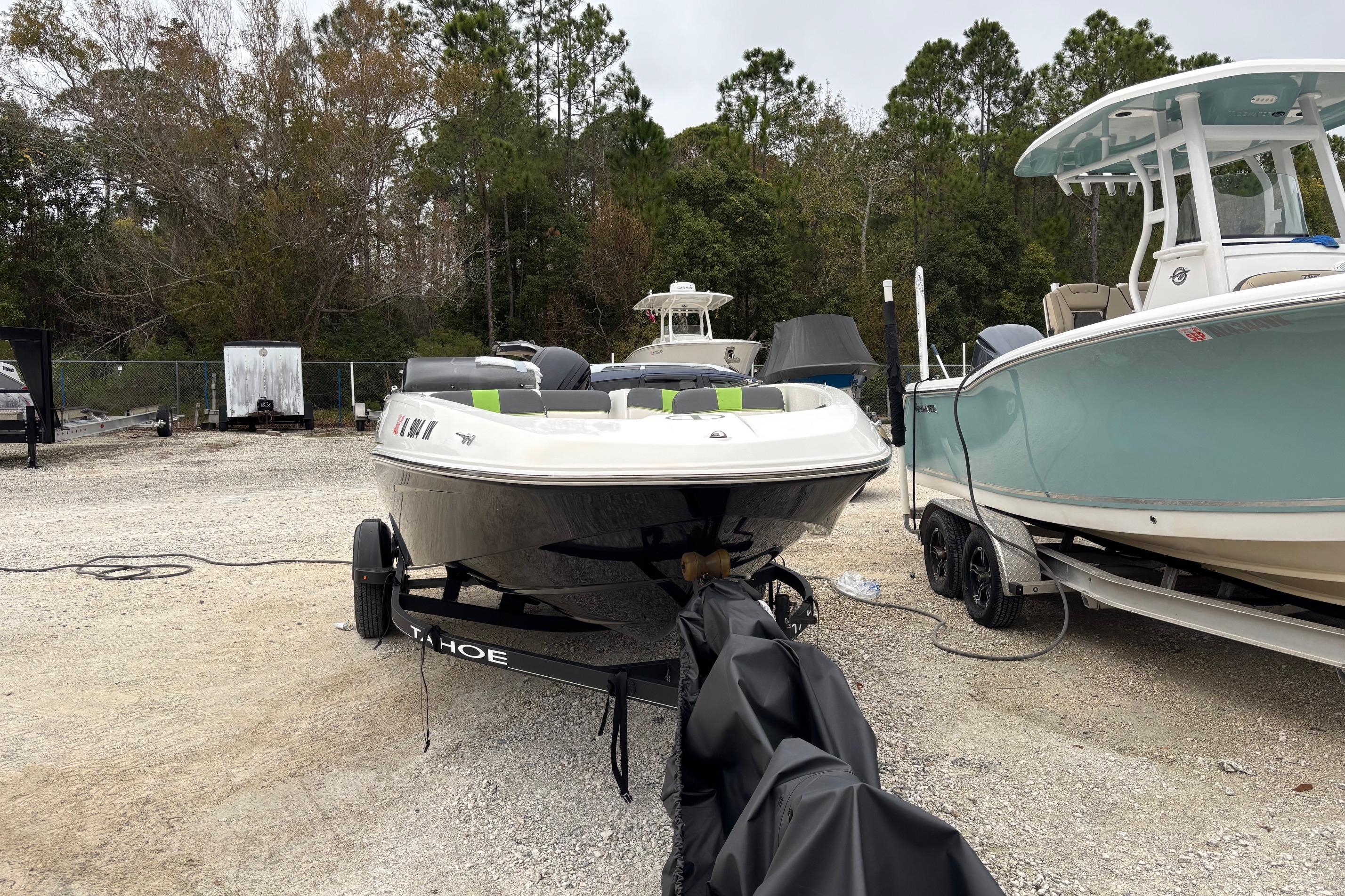 2022 Tahoe T16 boat on trailer, parked outdoors near other boats.