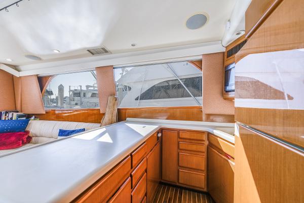 Interior of 1999 Viking 47 Convertible yacht with wooden cabinetry and large windows.