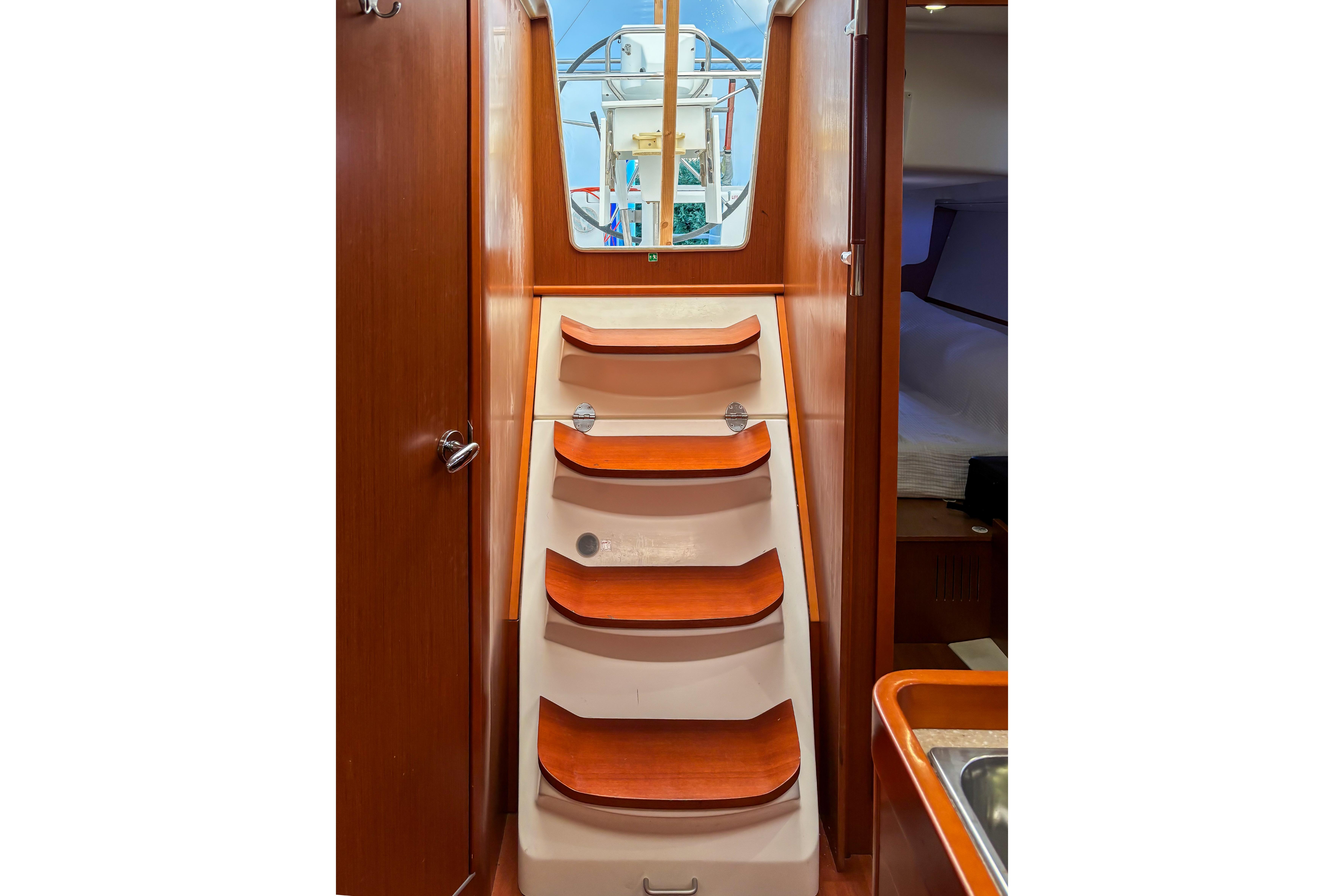 Interior view of 2015 Beneteau Oceanis 37 sailboat with wooden steps and cabin access.