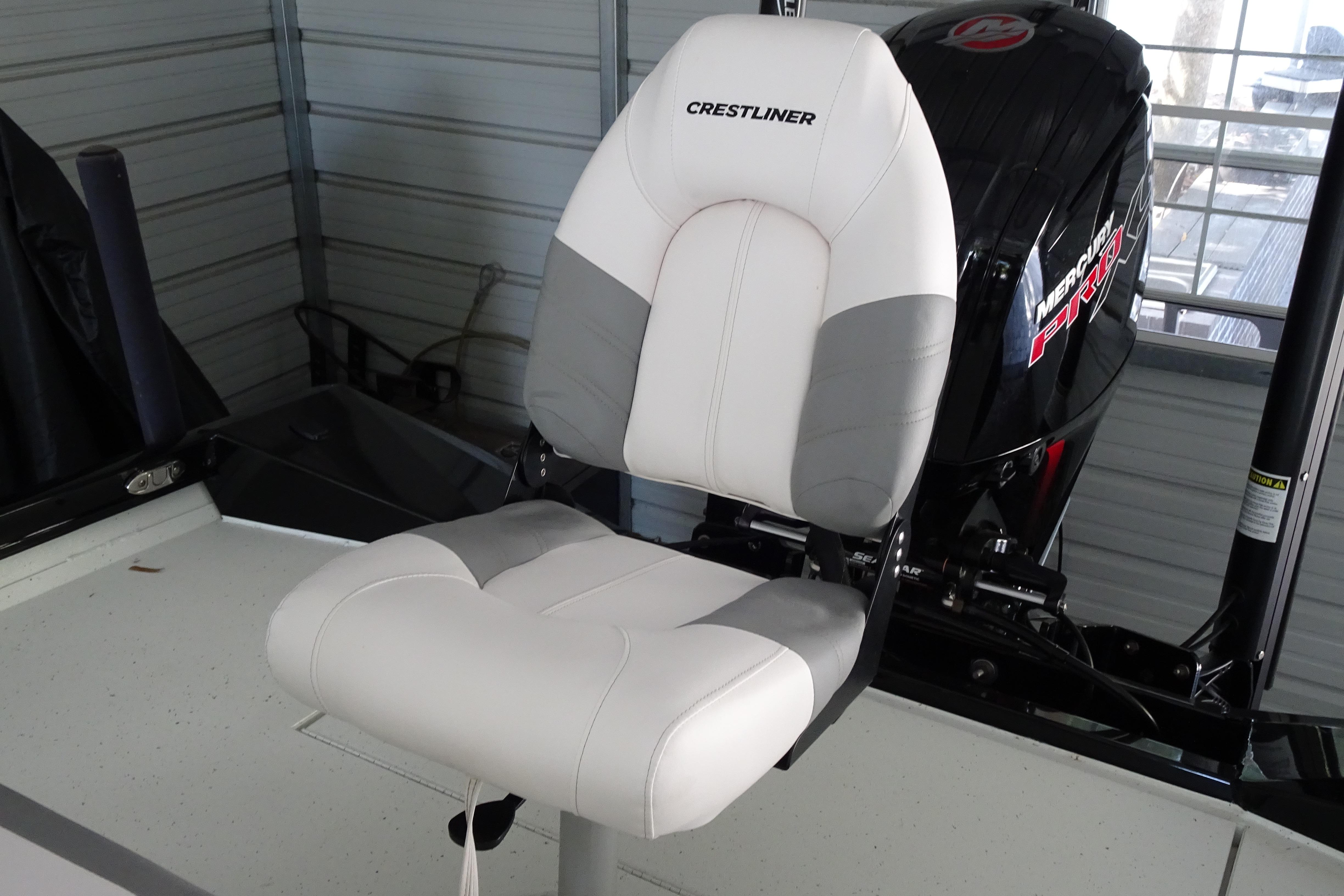 2023 Crestliner 2000 Bay boat seat with Mercury engine in a garage setting.