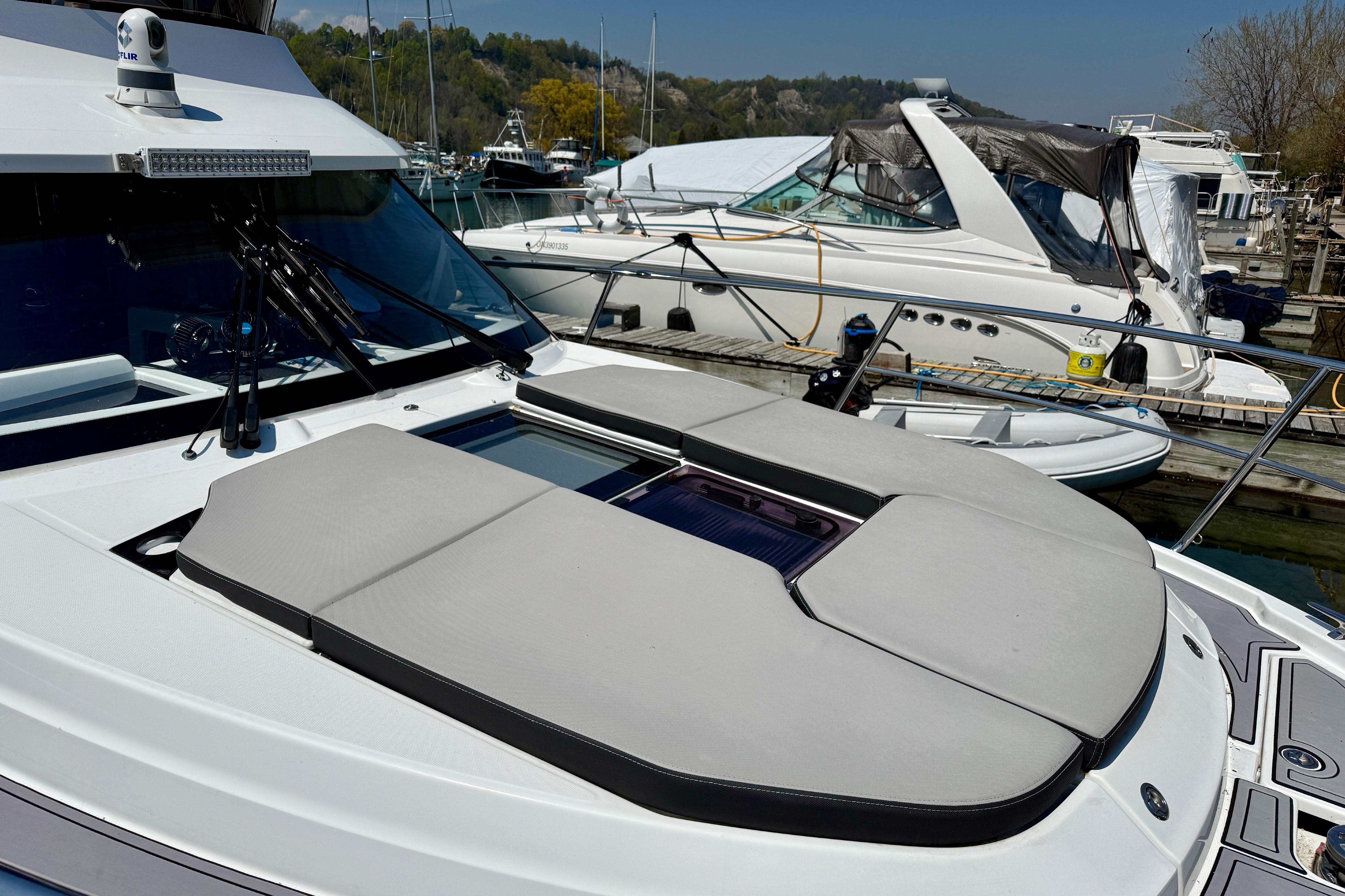 2022 Jeanneau NC 1095 Fly yacht with sunbathing deck, docked at marina.