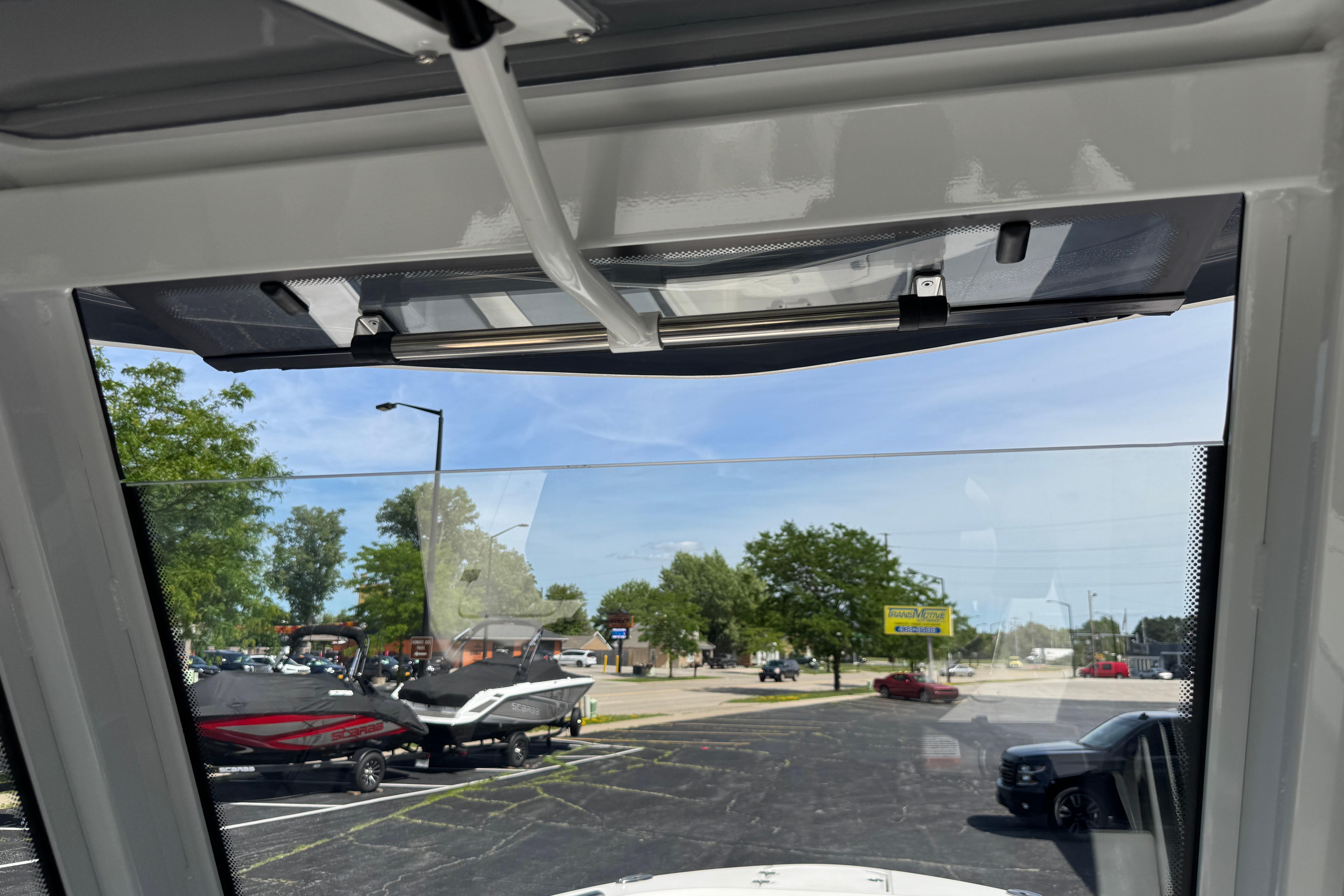Interior view from a 2026 Robalo R250 Center Console boat, overlooking a parking lot.