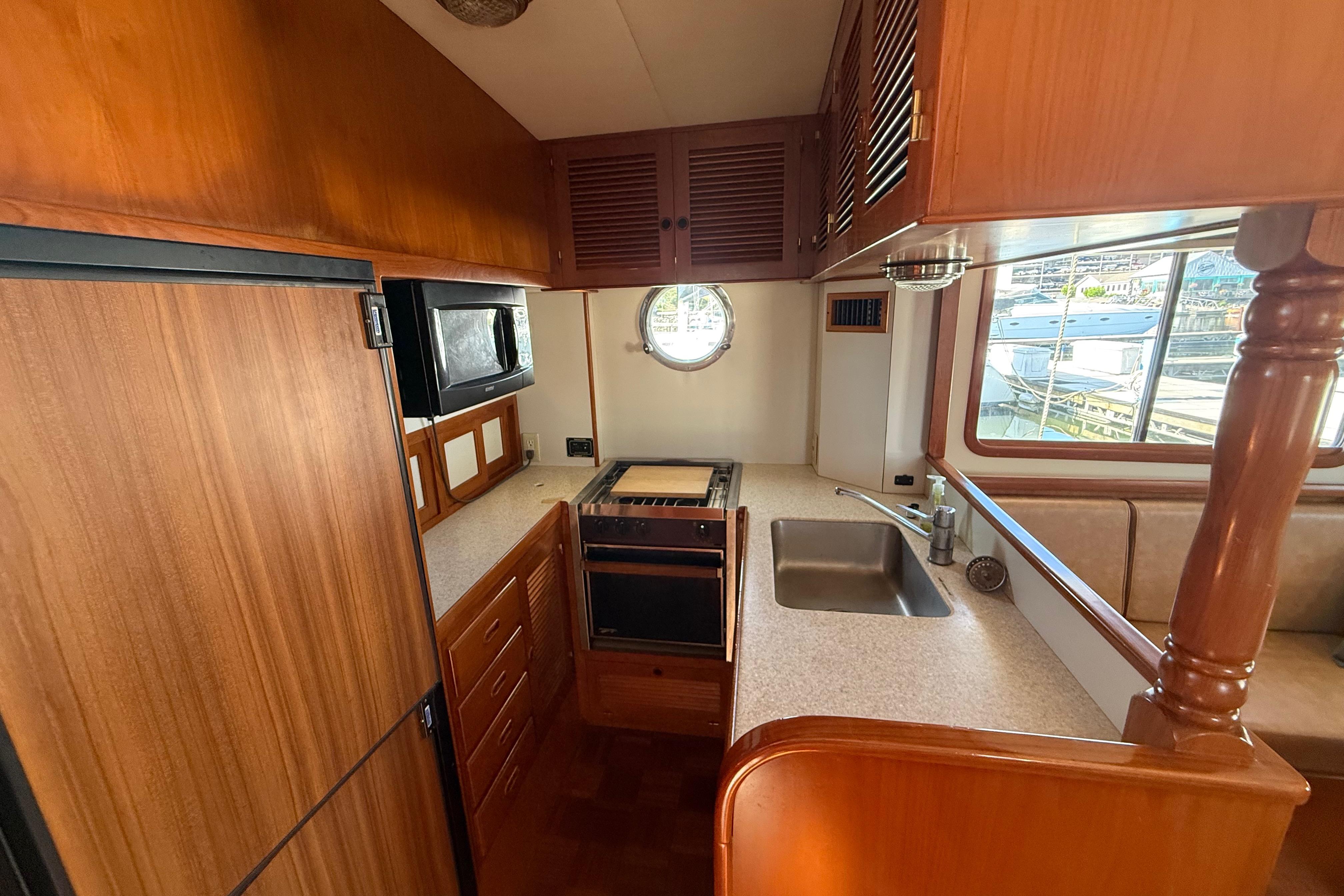 2001 Kadey-Krogen 39 yacht kitchen with wood cabinetry, sink, and appliances.