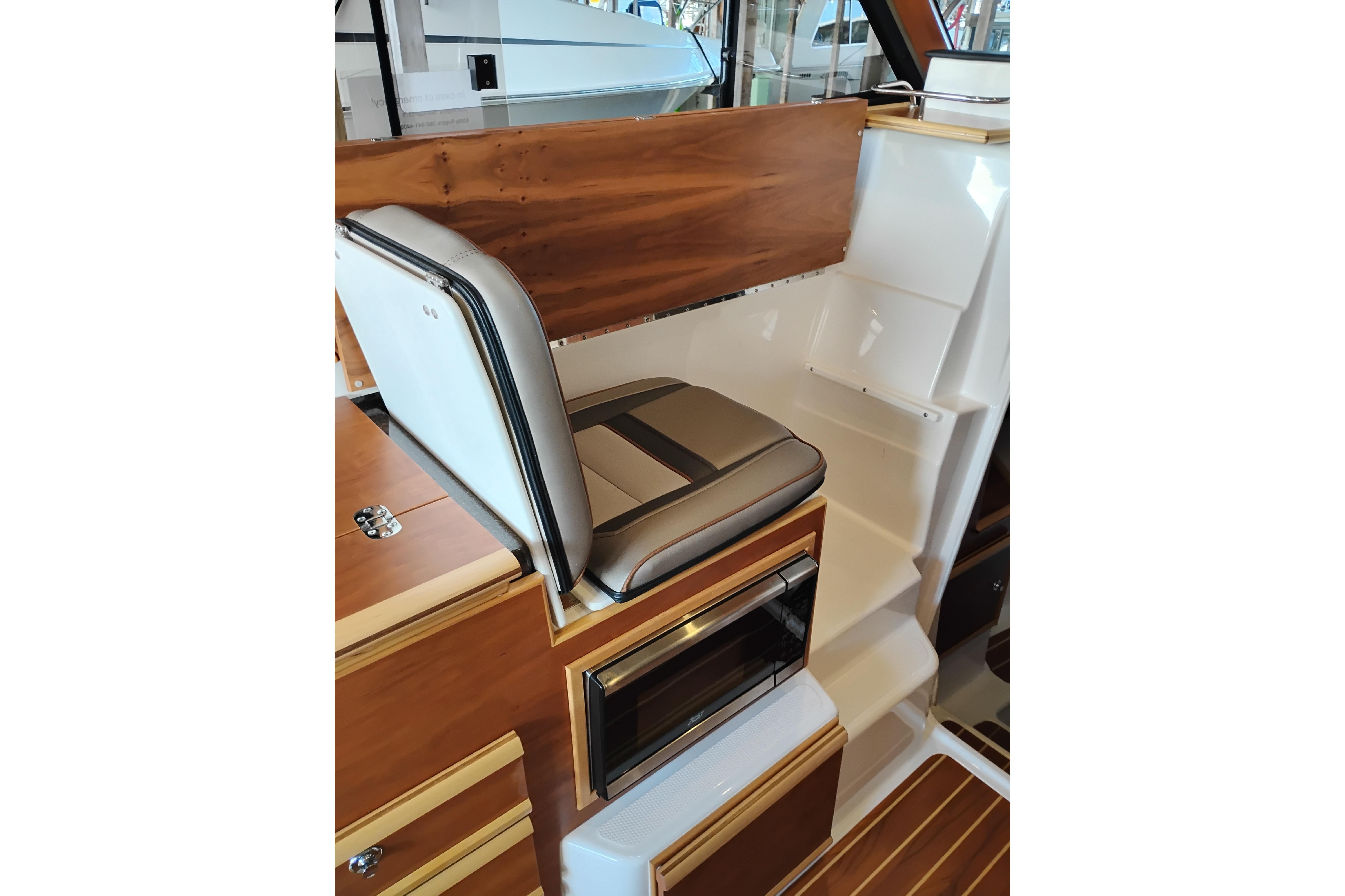 Interior of 2022 Cutwater C-32 Coupe featuring a stylish seat and wooden cabinetry.