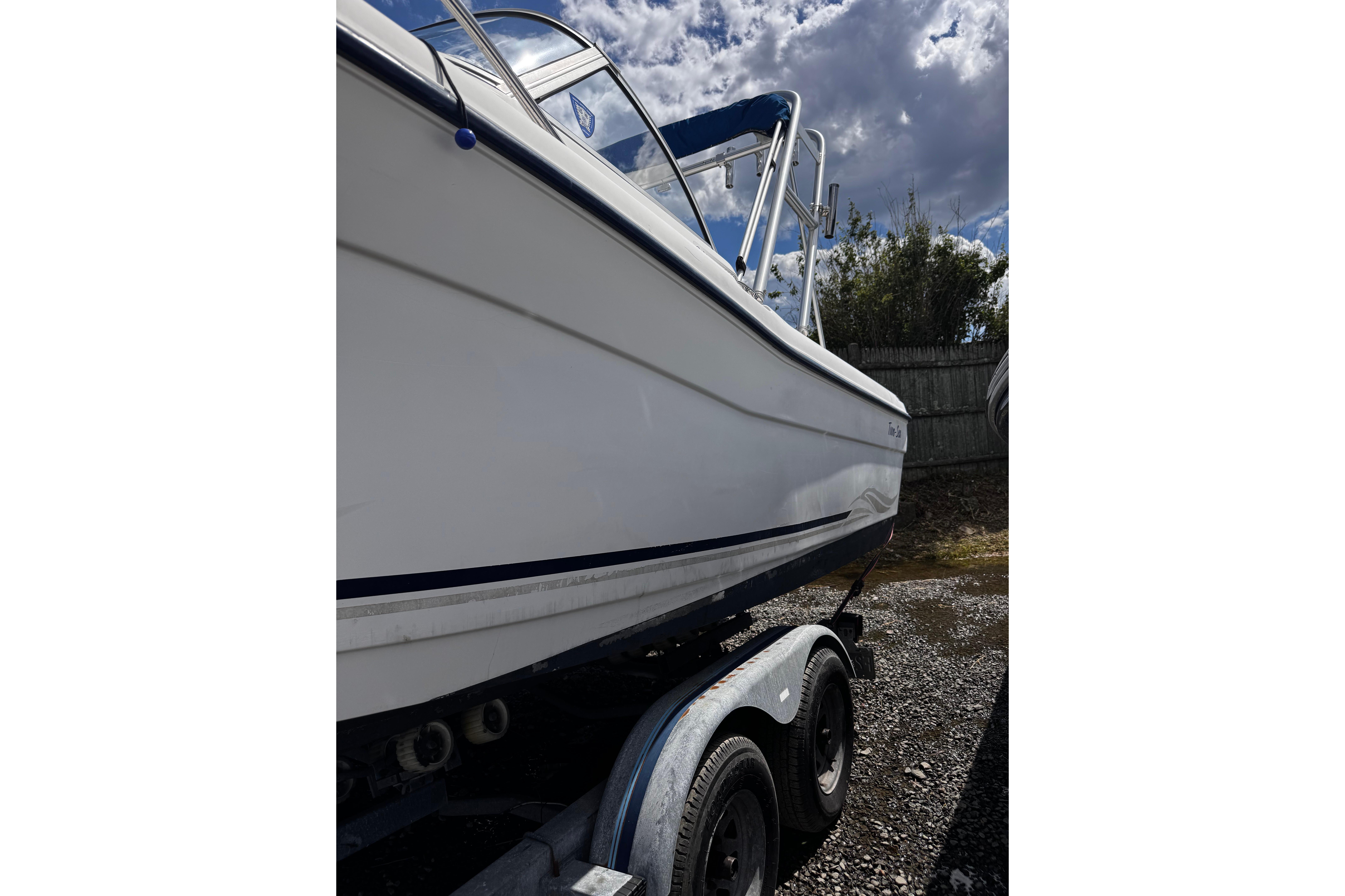 2003 Palm Beach 2200 Dual Console boat on trailer under cloudy sky.