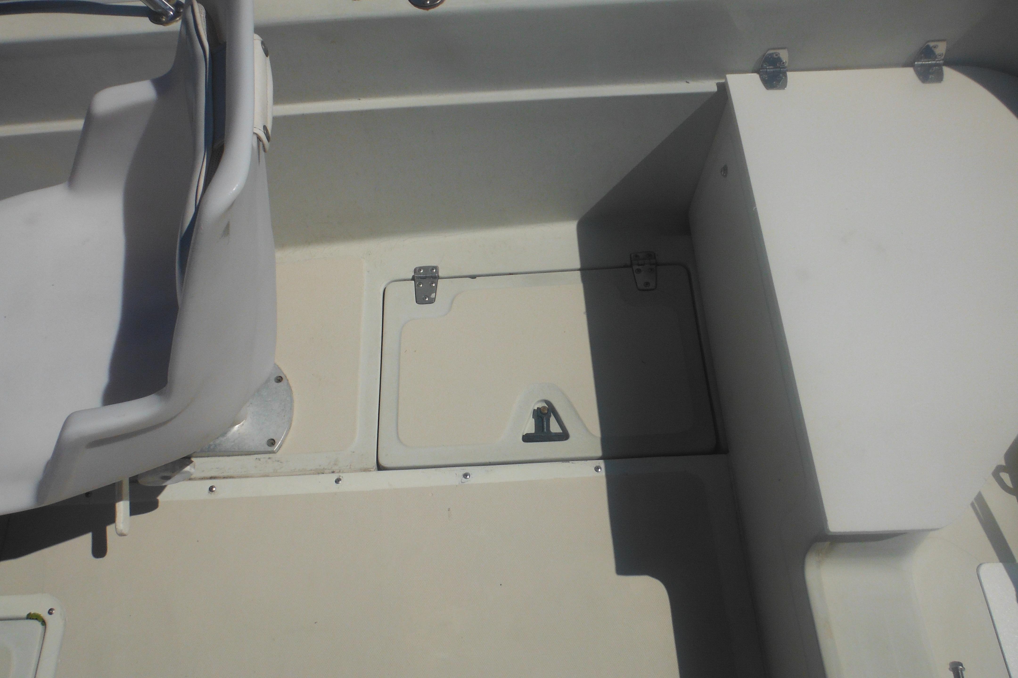 Interior of a 1991 Boston Whaler 16 SL boat showing seating and storage compartment.