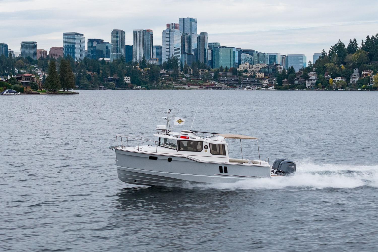 2026 Ranger Tugs R-27 cruising on a lake with city skyline in background.
