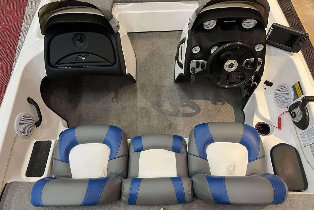 2005 Nitro NX 750 boat interior with blue and gray seating, steering console, and dashboard controls.