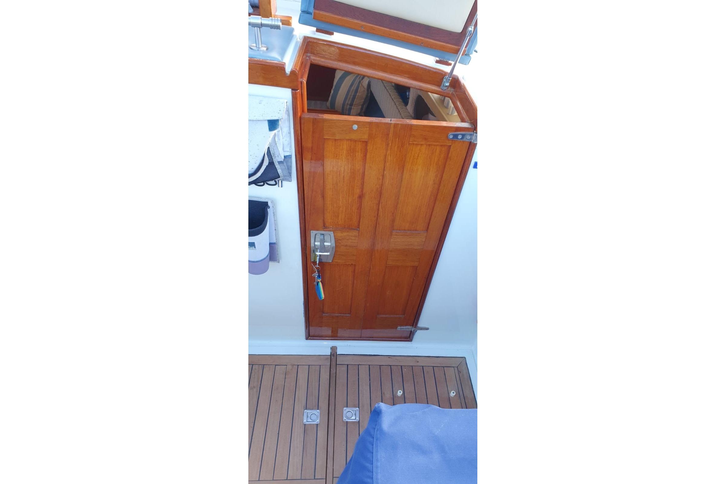 Wooden cabin door on 1989 Fairey Spearfish MKIII boat, with teak flooring and blue cover.