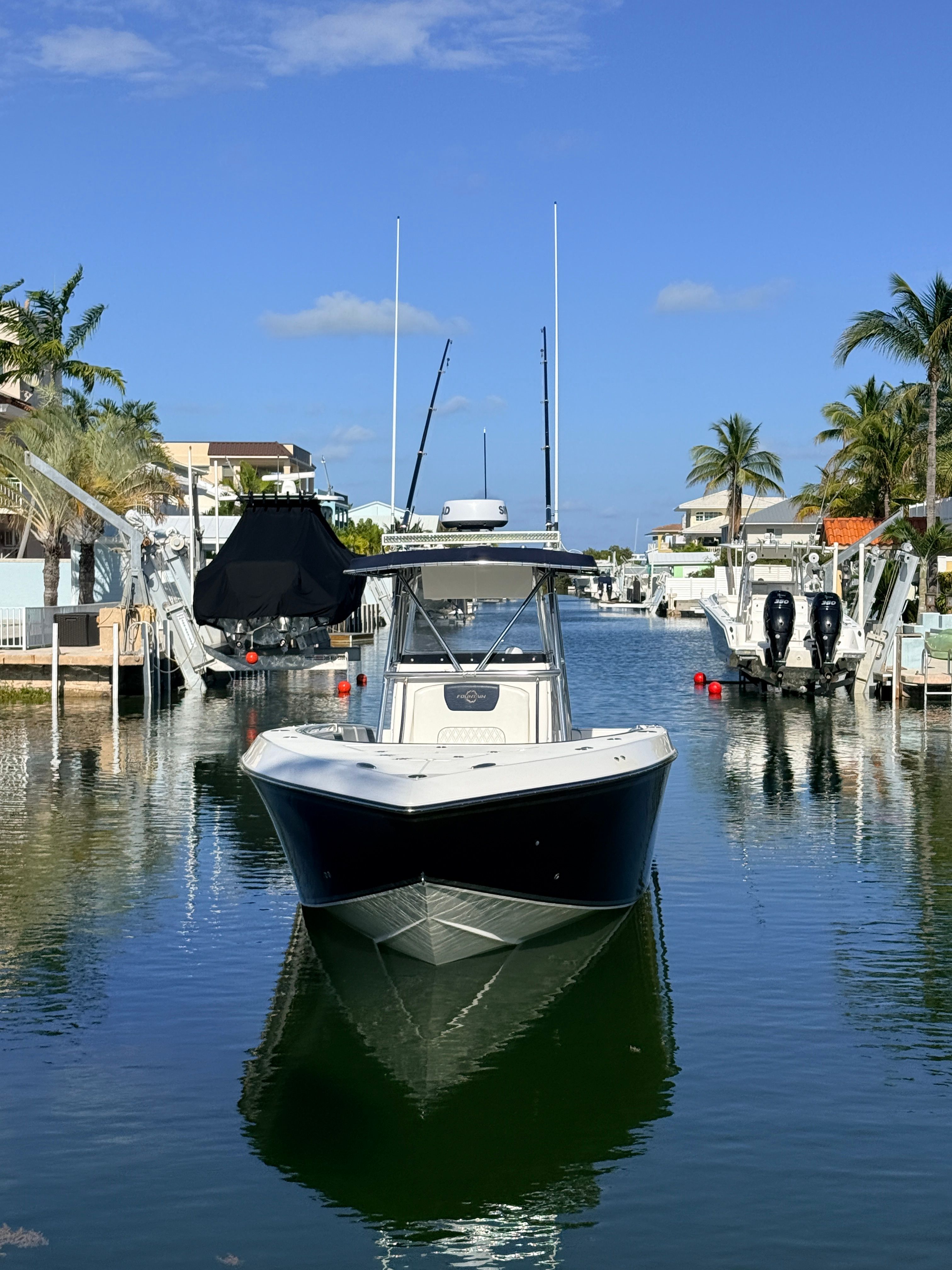 2007 Fountain 32 Center Console docked in marina, surrounded by palm trees.