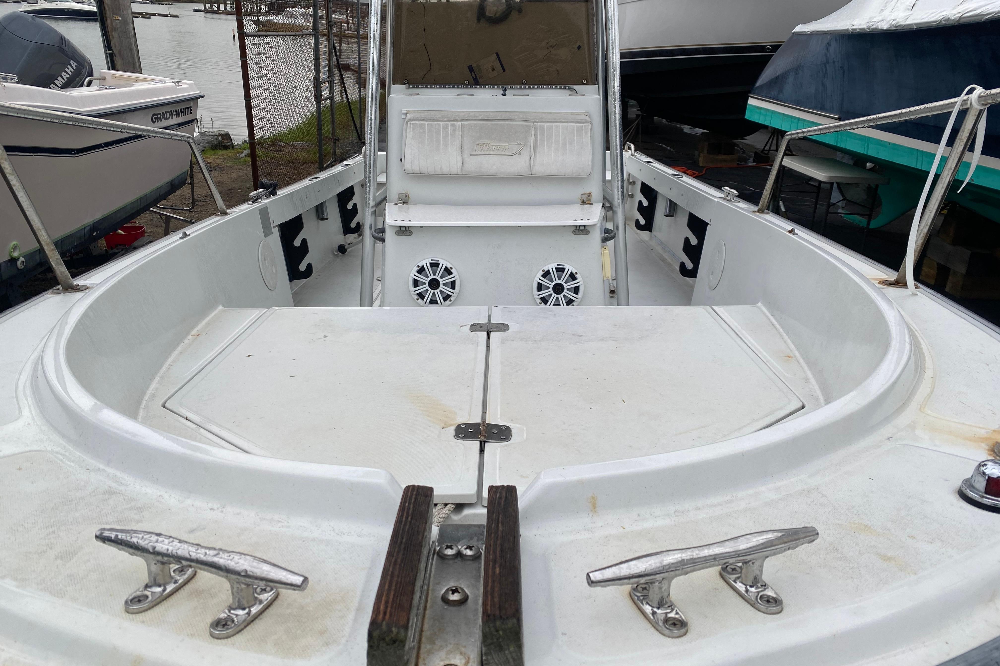 1994 Boston Whaler 19 OUTRAGE boat interior with seating and speakers, docked near other boats.